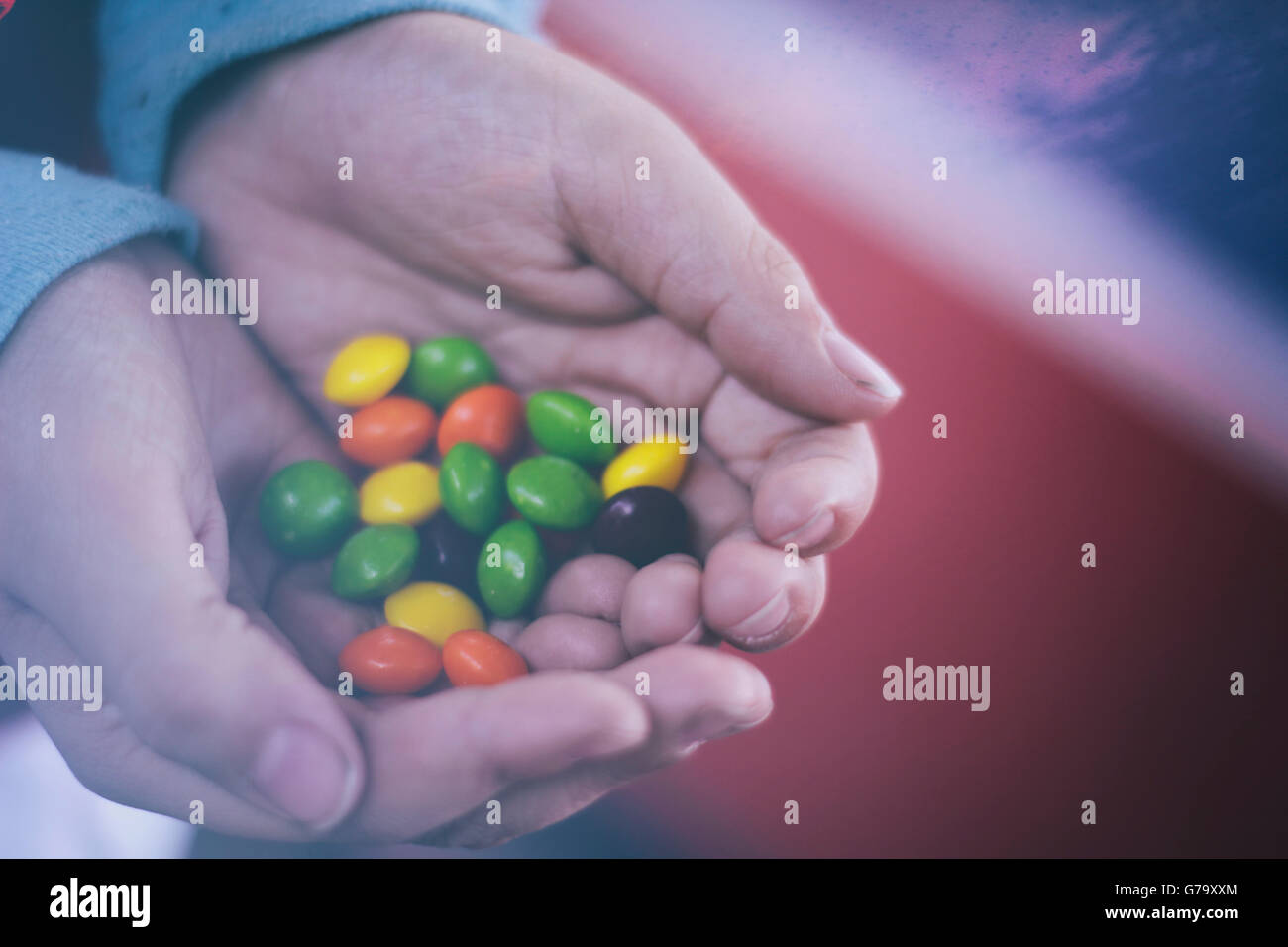 Phoograph einige menschliche Hände halten einige bunte Bonbons Stockfoto