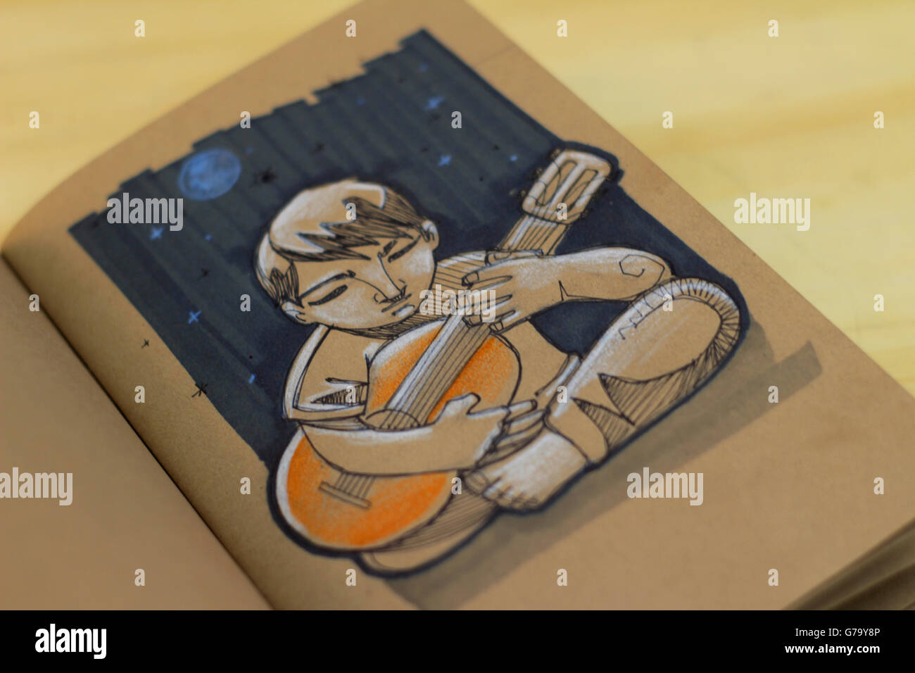 Foto von einem Musiker, spielt seine Gitarre, Zeichnung auf einem notebook Stockfoto