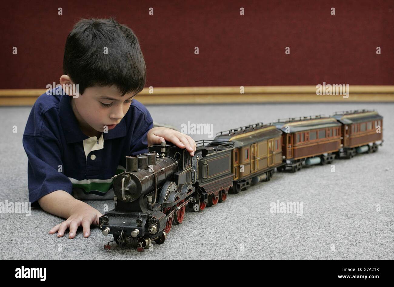 Ian Scoville, 7, mit Blick auf eine seltene „Black Prince“-Lokomotive und einen sechsrädrigen Tender im Wert von 7000 bis 10,000 - die Wagen haben einen Gesamtwert zwischen 7000 und 10,000 - Freitag, 3. September 2004 aus der David Pressland Collection mit feinem Penny-Spielzeug und Weißblech, Eine der besten Spielzeugkollektionen der Welt, bevor sie bei Christie's in London versteigert wurde. Stockfoto