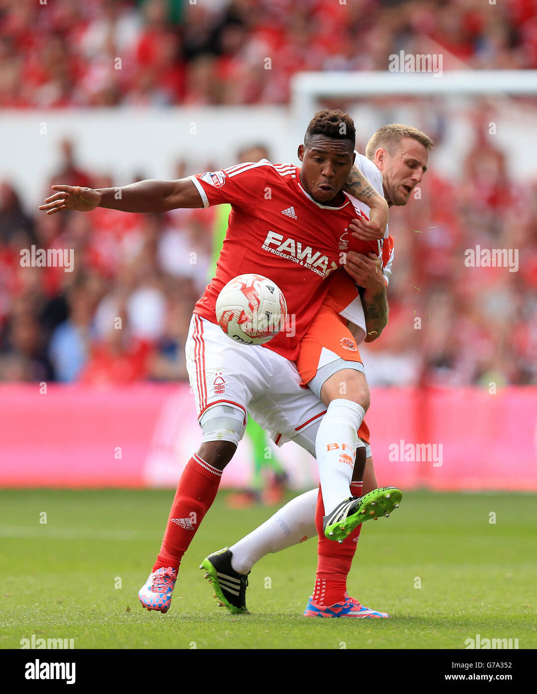 Blackpools Peter Clarke (rechts) und Britt Assombalonga von Nottingham Forest kämpfen während des Sky Bet Championship-Spiels auf dem City Ground, Nottingham, um den Ball. DRÜCKEN SIE VERBANDSFOTO. Bilddatum: Samstag, 9. August 2014. Siehe PA Geschichte FUSSBALL Nottm Forest. Bildnachweis sollte lauten: Mike Egerton/PA Wire. Stockfoto