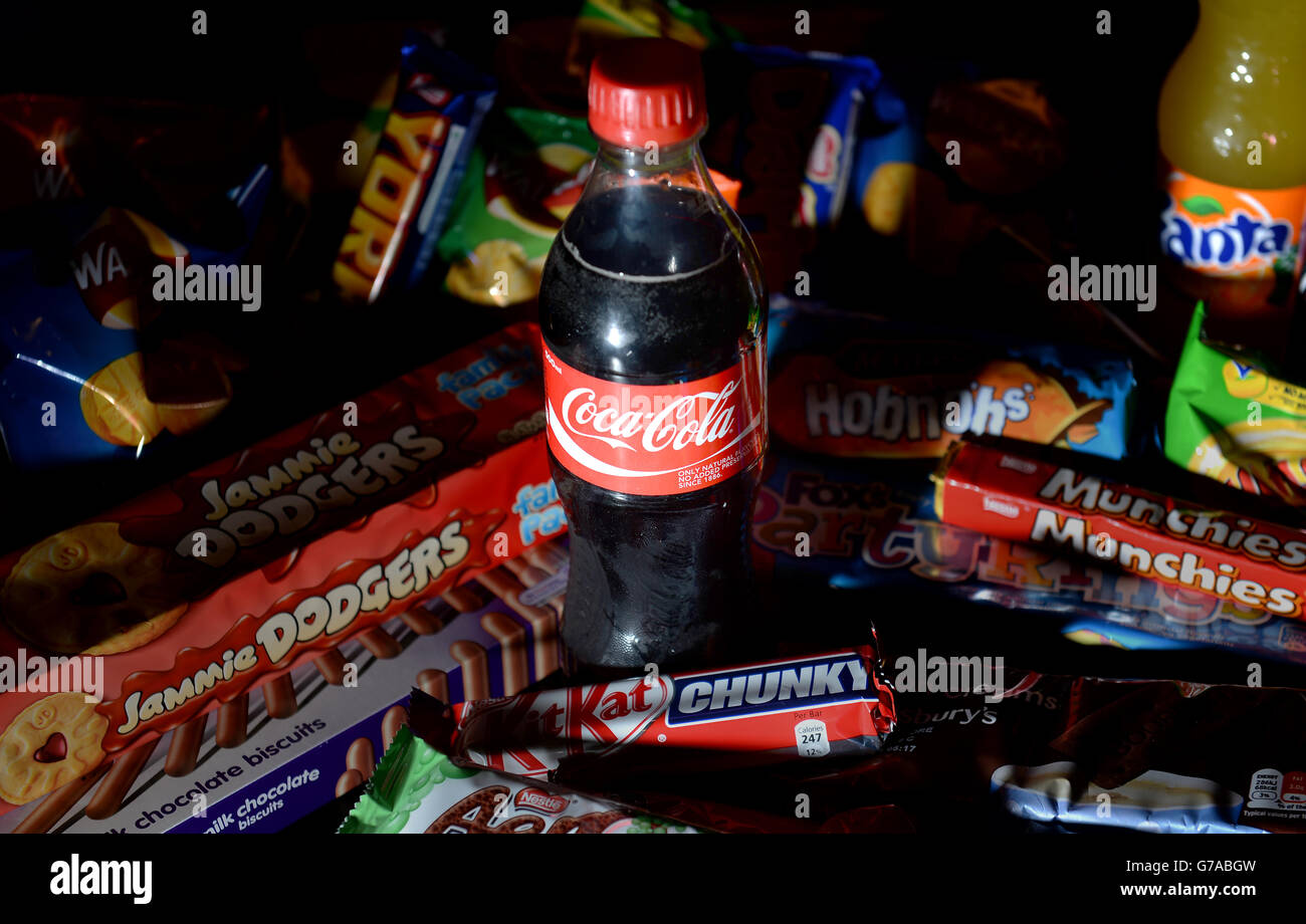 Stock Ungesunde Ernährung. Eine Flasche Coca Cola mit Keksen, Chips, Schokoriegel und kohlensäurehaltigen Getränken Stockfoto