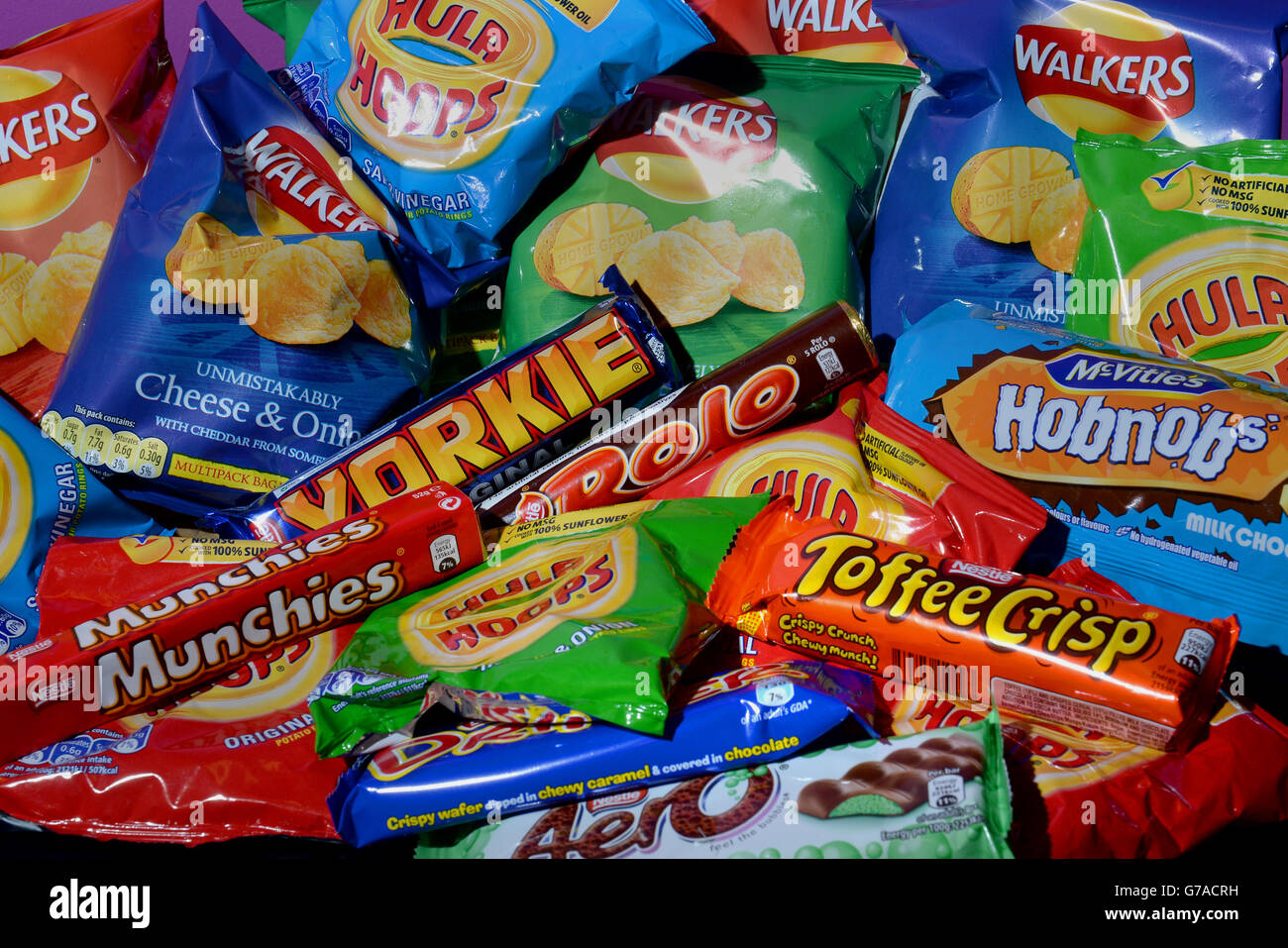 Stock Ungesunde Ernährung. Eine Auswahl an Keksen, Chips, Schokoladentafeln und kohlensäurehaltigen Getränken Stockfoto