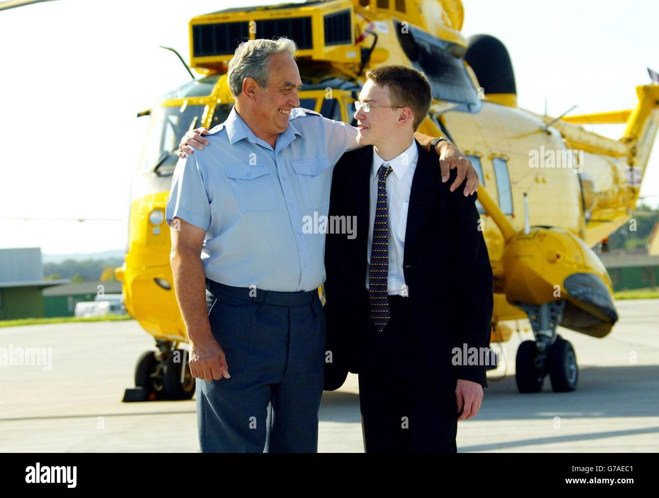 RAF Rescue Winchman, Bob Pountney mit dem 16-jährigen Sam Harcus auf dem Luftwaffenstützpunkt RAF Kinloss, Morayshire, Schottland, den er als Baby rettete. Herr Pountney tritt nach 44 Jahren in den Ruhestand. Stockfoto