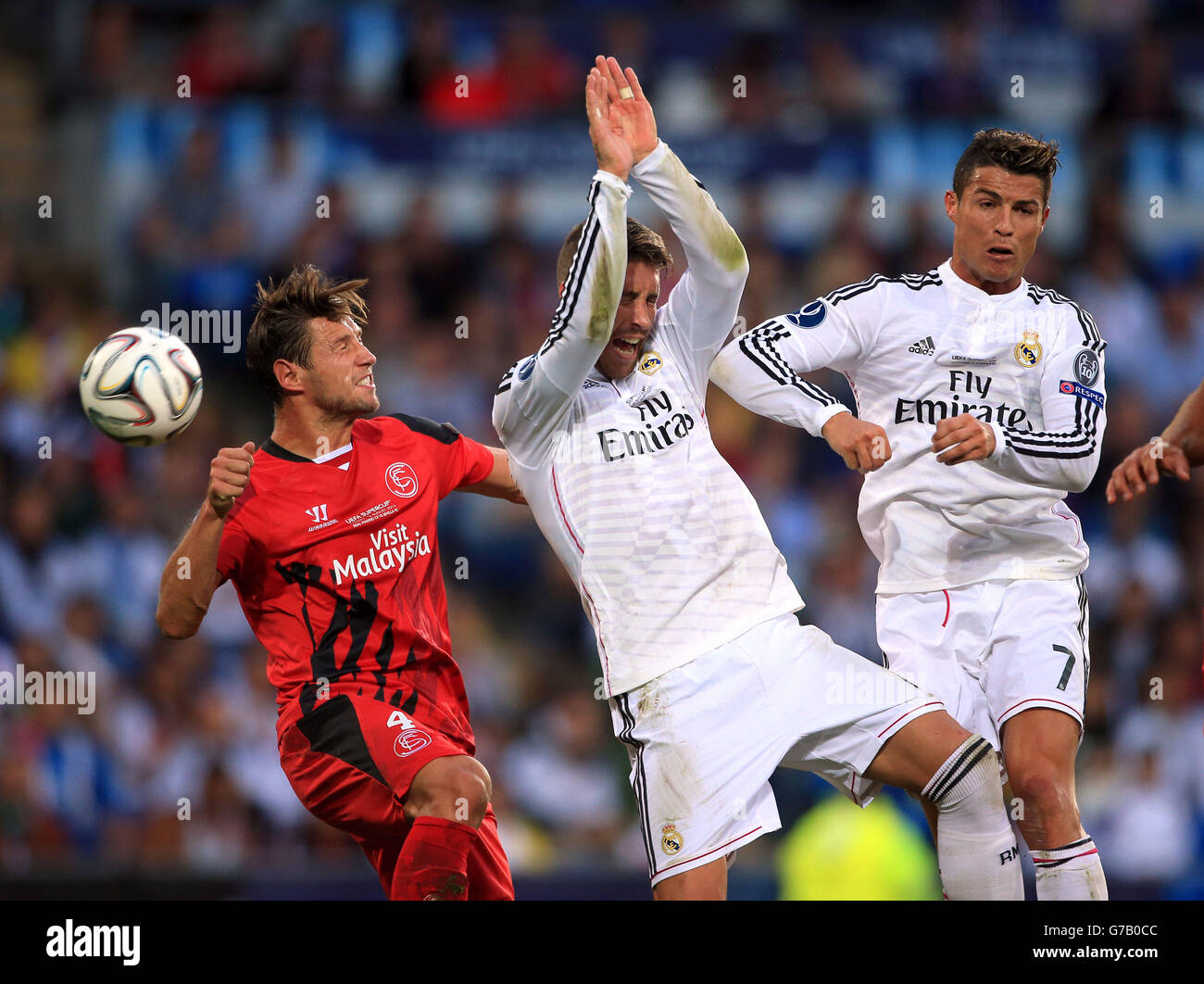 Fußball - UEFA Super Cup 2014 - Sevilla / Real Madrid - Cardiff City Stadium. Sevillas Grzegorz Krychowiak (links) und Sergio Ramos und Cristiano Ronaldo von Real Madrid kämpfen um den Ball Stockfoto