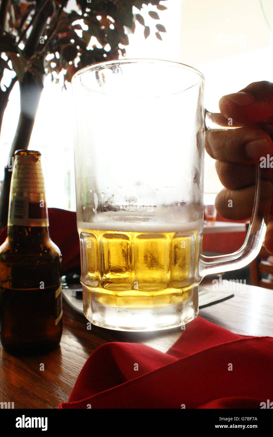 Foto von einem Glas Bier hob eine Hand Stockfoto