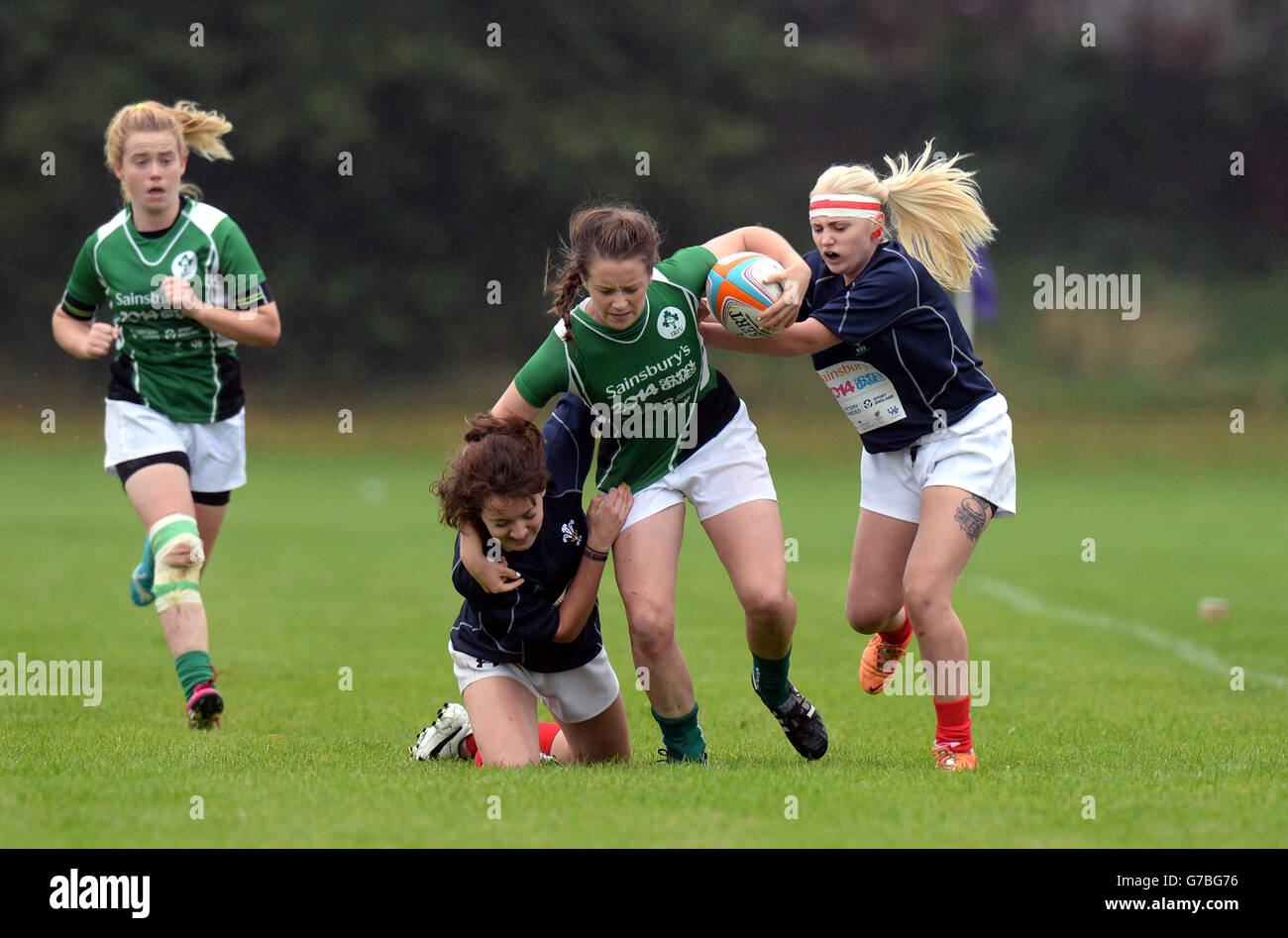 Die irische Stacey Flood wird von Annie Bevan (rechts) und Emma Hennnessy aus Wales B bei den Schulspielen von Sainsbury 2014, Armitage Site, Manchester, in den Rugby Sevens angegangen. Stockfoto