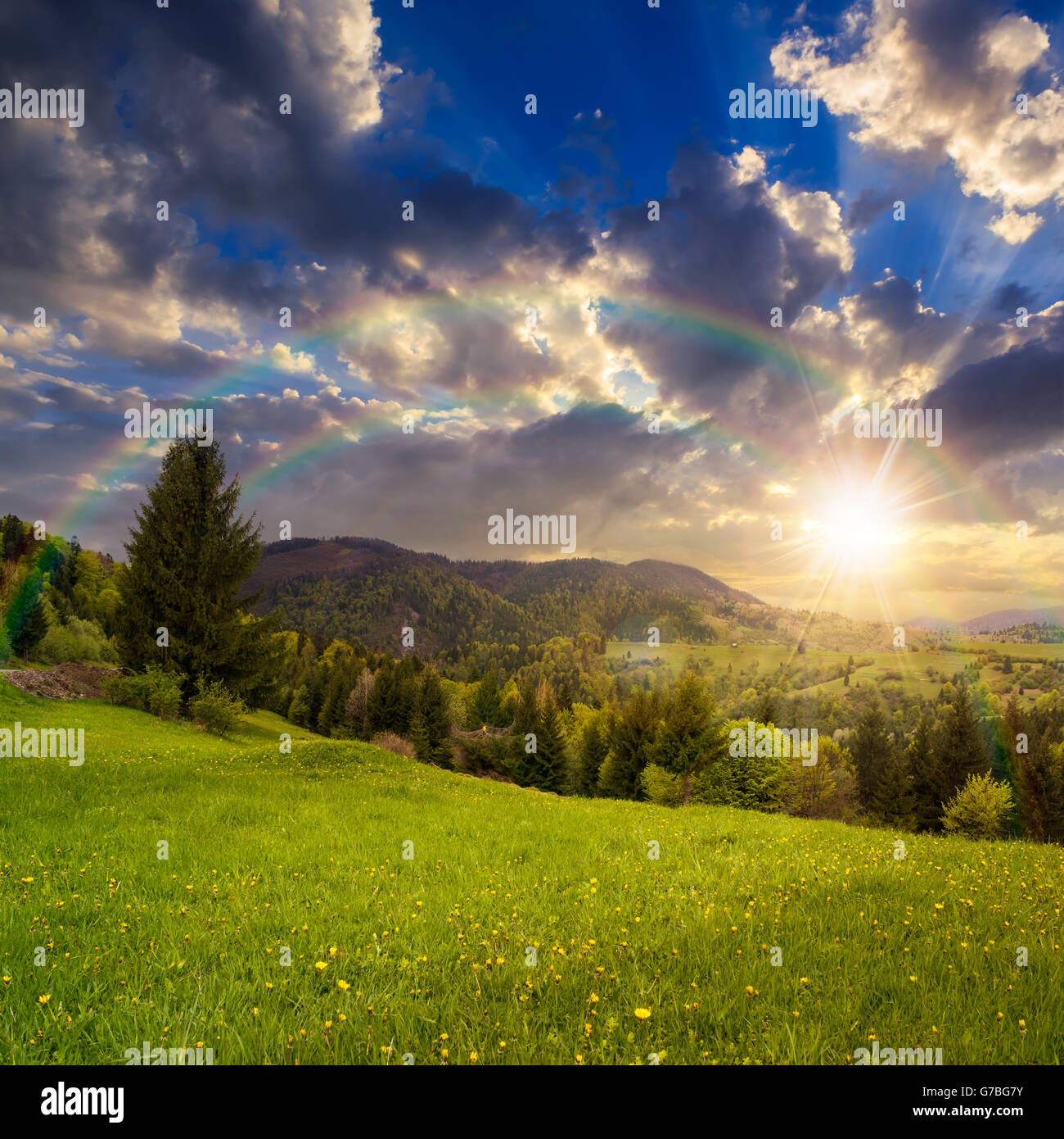 Wiese Abhang des Gebirges mit Nadelwald und Dorf am Sunset Stockfoto