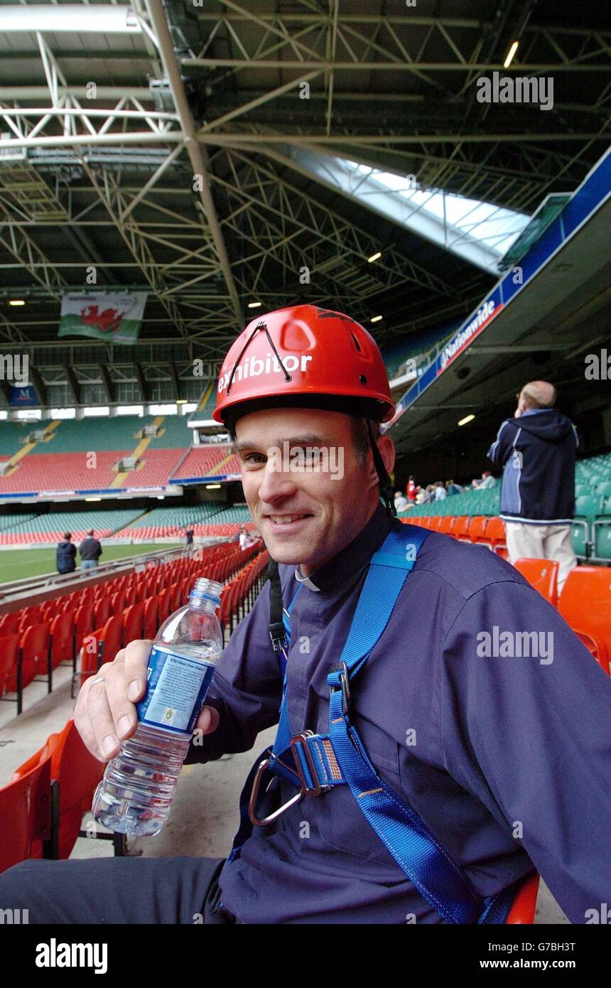 Methodistenminister Rev. Andrew Webster nach seinem Abseilen vom Dach des Millennium Stadions in Cardiff. Ein „Vertigo Vikar“ hat seine lebenslange Höhenangst überwunden, indem er heute auf die Spitze des Millennium Stadions kletterte. Der Methodistenminister von Cardiff, Rev. Andrew Webster, 32, machte eine Wohltätigkeitsaktion und stürzte 90 Meter vom Dach auf den Platz in seinem Hundehalsband, um Geld für die Kinderhilfe NCH zu sammeln. Stockfoto