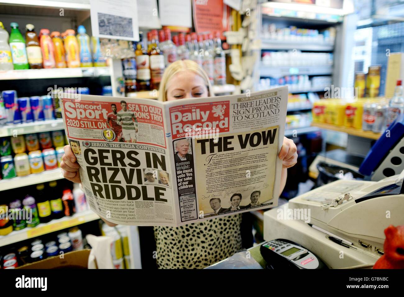 Eine Dame liest den Daily Record in Edinburgh, der ein Versprechen der Führer der drei wichtigsten Parteien in Westminster für mehr Mächte in Schottland enthält, wenn es die Unabhängigkeit vor dem schottischen Unabhängigkeitsreferendum am Donnerstag ablehnt. Stockfoto
