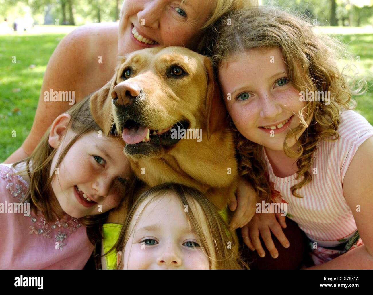 Besitzer Mhairi Thurston (oben), aus Dundee in Schottland und ihre Kinder (im Uhrzeigersinn von rechts) Christina, 8 Jahre alt, Caroline, 4, und Kathryn, 7, posiert mit Wanda, einem zweijährigen, 10 Monate alten labrador-Retriever-Kreuz, das den von der Guide Dogs for the Blind Association verliehenen Wettbewerb Guide Dog of the Year im Green Park im Zentrum von London gewann. Stockfoto