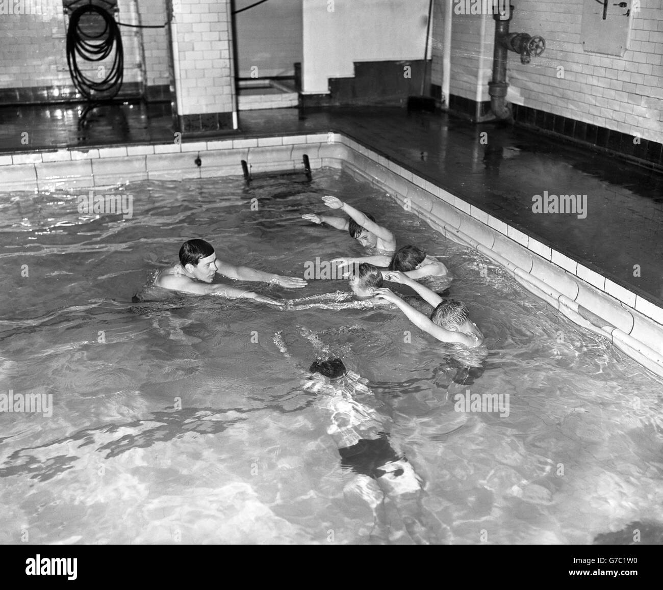 Jungen wird im Y.M.C.A in der Russell Street, London, das Schwimmen beigebracht. Stockfoto