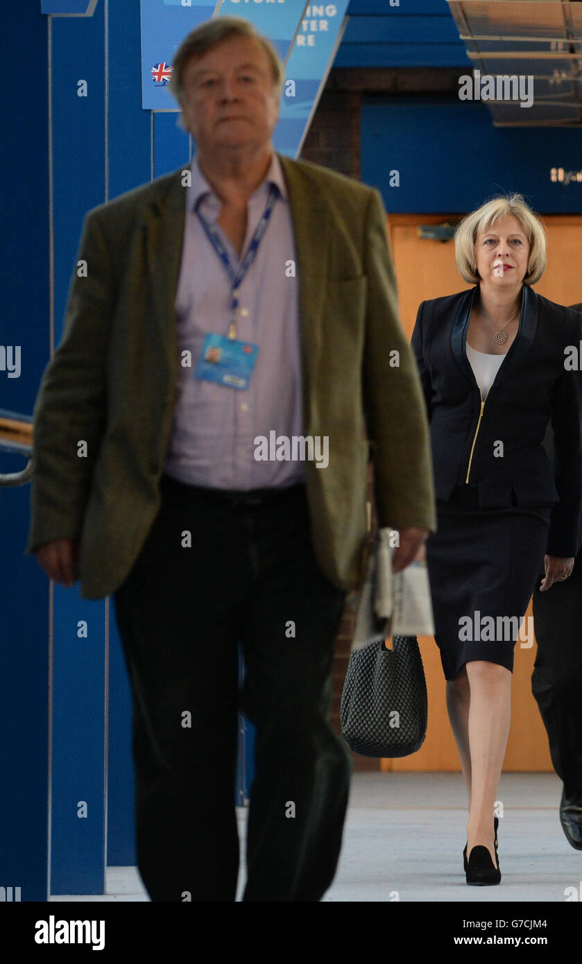 Innenministerin Theresa May folgt einem ihrer Vorgänger, Ken Clarke, als sie von ihrem Hotel zum International Convention Centre in Birmingham geht, bevor sie an die Konferenz der Konservativen Partei antritt. Stockfoto