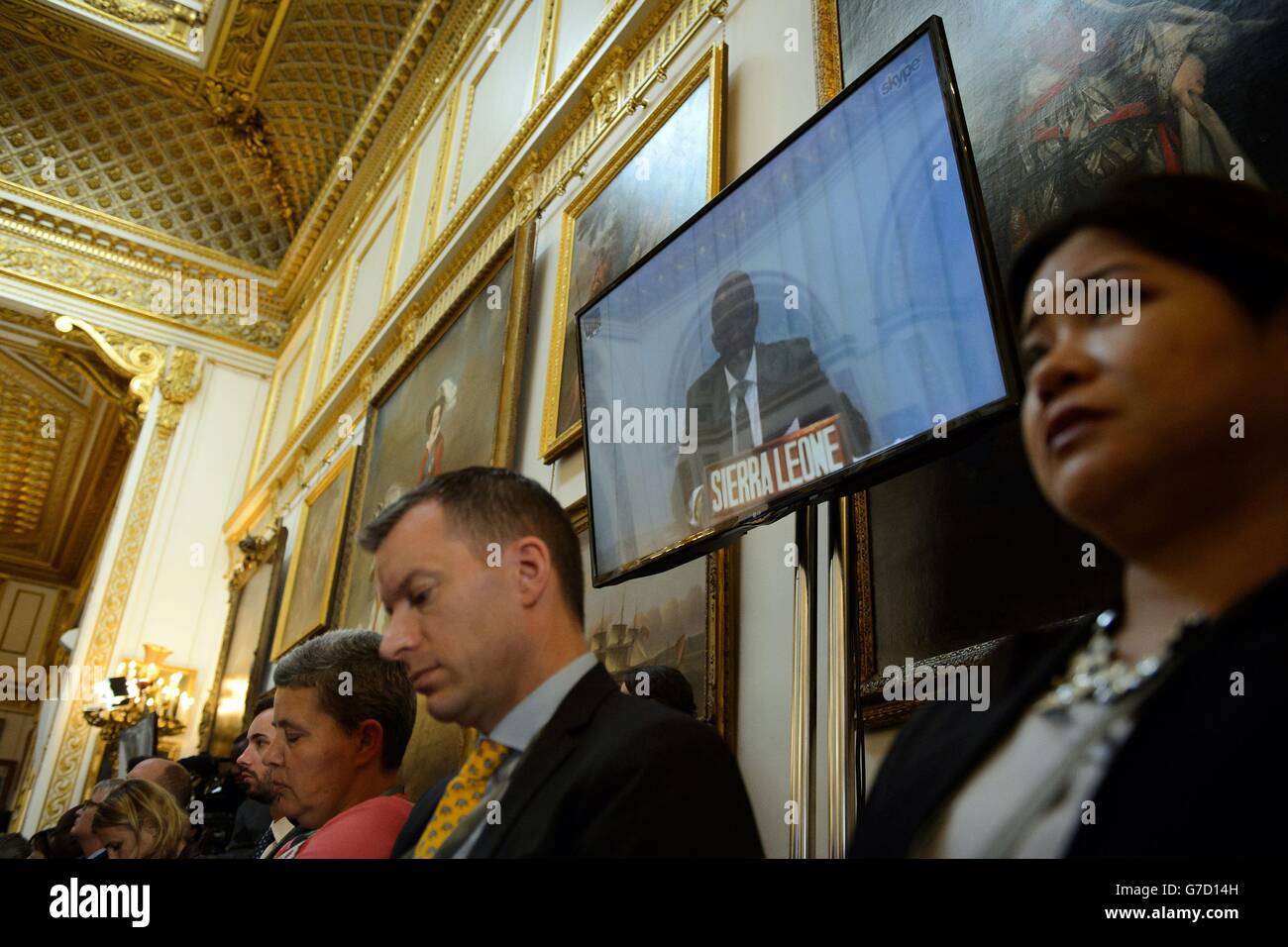 Ein Vertreter der Regierung von Sierra Leone spricht während der Konferenz "Defeating Ebola in Sierra Leone" im Lancaster House in London mit den Delegierten per Videolink. Stockfoto