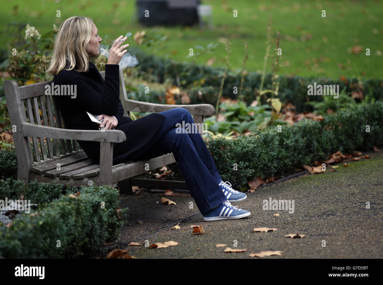 Eine Frau raucht im St. James' Park, London, eine Zigarette, nachdem der Bericht der Londoner Gesundheitskommission mit einer Empfehlung eines Gesundheitsgremiums veröffentlicht wurde, das tausende Hektar Parklandschaft in London und Wahrzeichen, einschließlich Trafalgar Square, rauchfreie Zonen schaffen würde. Stockfoto