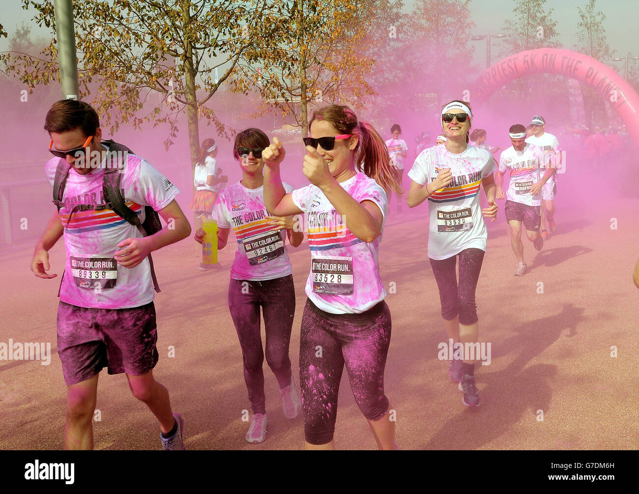 Die Teilnehmer nehmen am Dulux Color Run Teil, die Läufer werden auf jedem Kilometer der Strecke im Queen Elizabeth Olympic Park, Stratford East London, mit farbigem Pulver bedeckt. Stockfoto