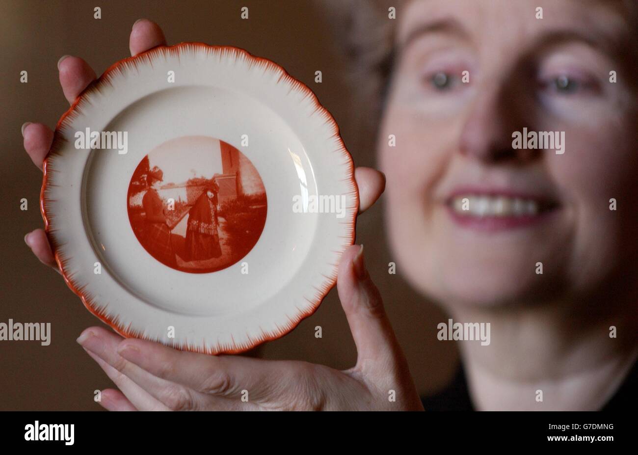 Frances Dimond, Kuratorin einer Foto- und Kunstausstellung des Gemahls Edward VII., Königin Alexandra, hält einen Porzellanteller mit einem Foto von Königin Alexandra von ihrer Schwiegermutter, Königin Victoria, mit ihrer Enkelin Prinzessin Louise, aufgenommen 1890 auf dem Gelände des Abergeldie Castle, Schottland. Die Ausstellung, die am 9. Oktober im Schloss Windsor eröffnet wird, umfasst Gegenstände, die bisher in der Öffentlichkeit nicht gesehen wurden. Stockfoto