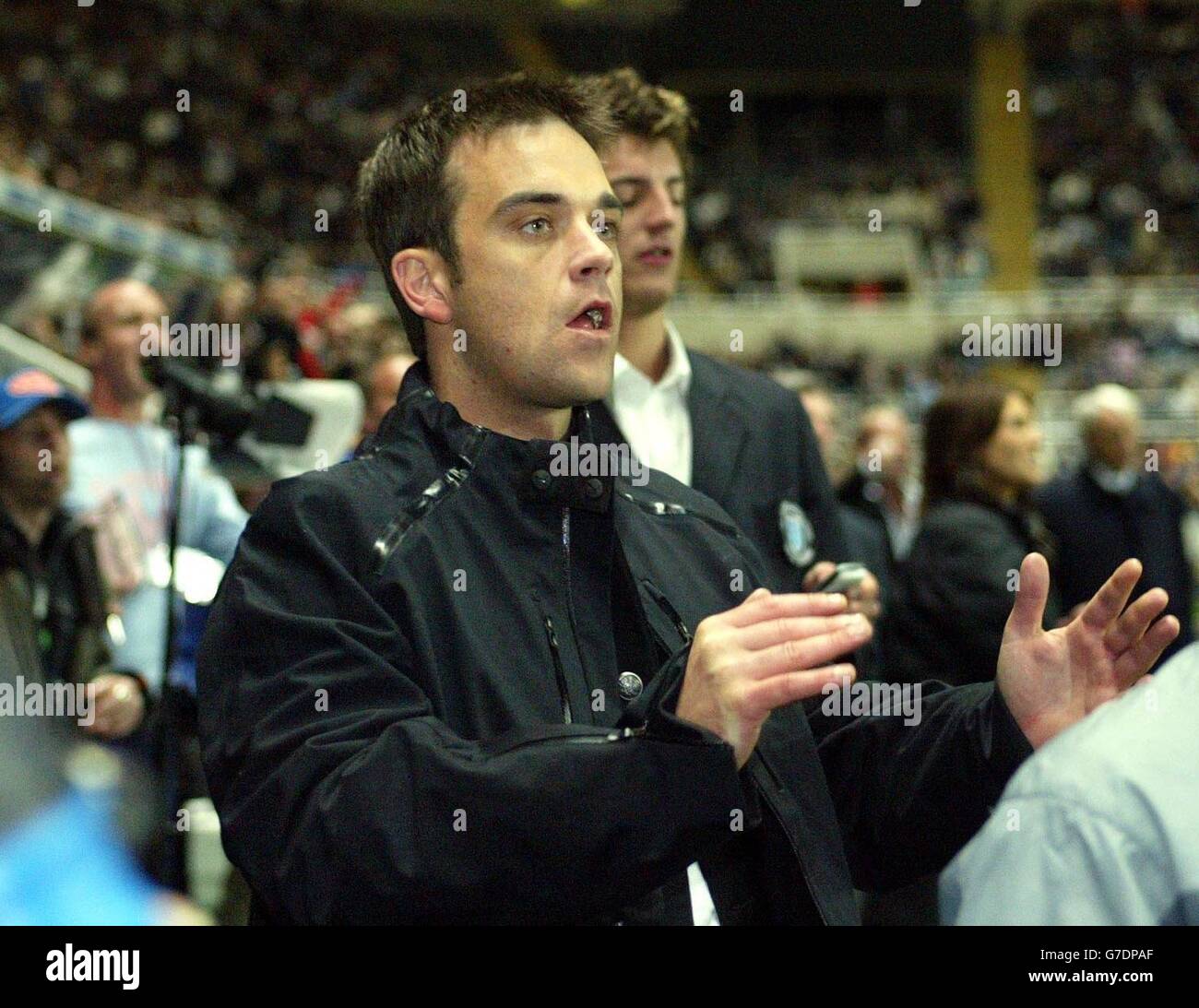 Popstar Robbie Williams am Rande jubelt über seine prominenten Freunde während Sky One's The Match im St. James Park von Newcastle United. Stockfoto