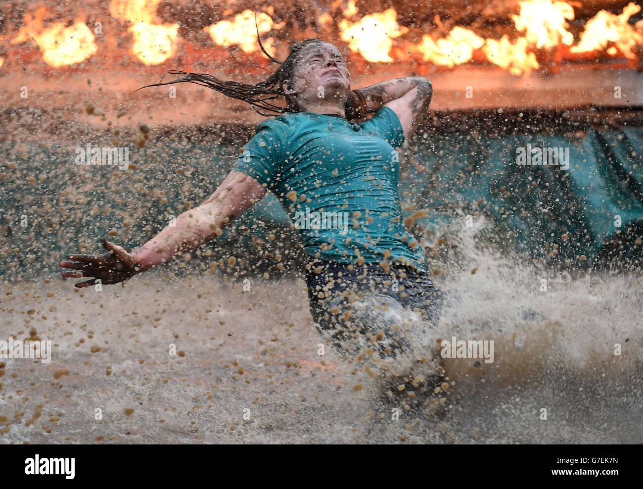 Ein Teilnehmer rutscht während des Tough Mudder London South beim Matterley Bowl in Winchester, Hampshire, nach „Fire in Your Hole“. Stockfoto