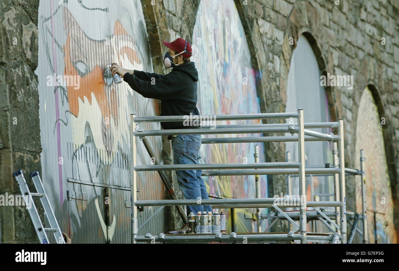 Ein Graffiti-Künstler beginnt mit der Arbeit an Schottlands größtem Street-Art-Projekt im Herzen der Altstadt von Edinburgh, wo sich eine Reihe von ständig wechselnden Leinwänden über einen halben Kilometer erstrecken wird. Stockfoto