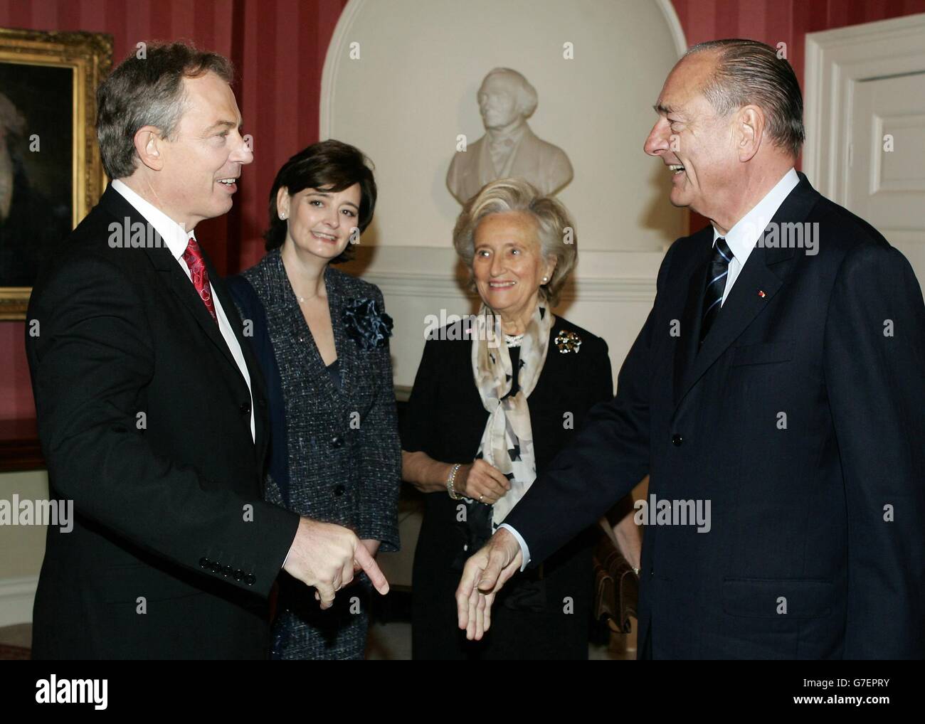 Der britische Premierminister Tony Blair begrüßt mit dem französischen Präsidenten Jacques Chirac, während Cherie Blair und Bernardette Chirac vor ihrem Treffen in der Downing Street 10 in London einen Blick darauf werfen. Chirac begann am Donnerstag einen zweitägigen Besuch in London für einen jährlichen englisch-französischen Gipfel mit dem Irak, der immer noch ein schmerzlicher Punkt in den Beziehungen zwischen den beiden europäischen Mächten ist. Chirac wird auch an festlichen Veranstaltungen teilnehmen, um das Ende der hundertjährigen Feierlichkeiten der Entente Cordiale zu begehen, dem Akt der Freundschaft, der das Bündnis zwischen Großbritannien und Frankreich durch zwei Weltkriege besiegelte. Stockfoto