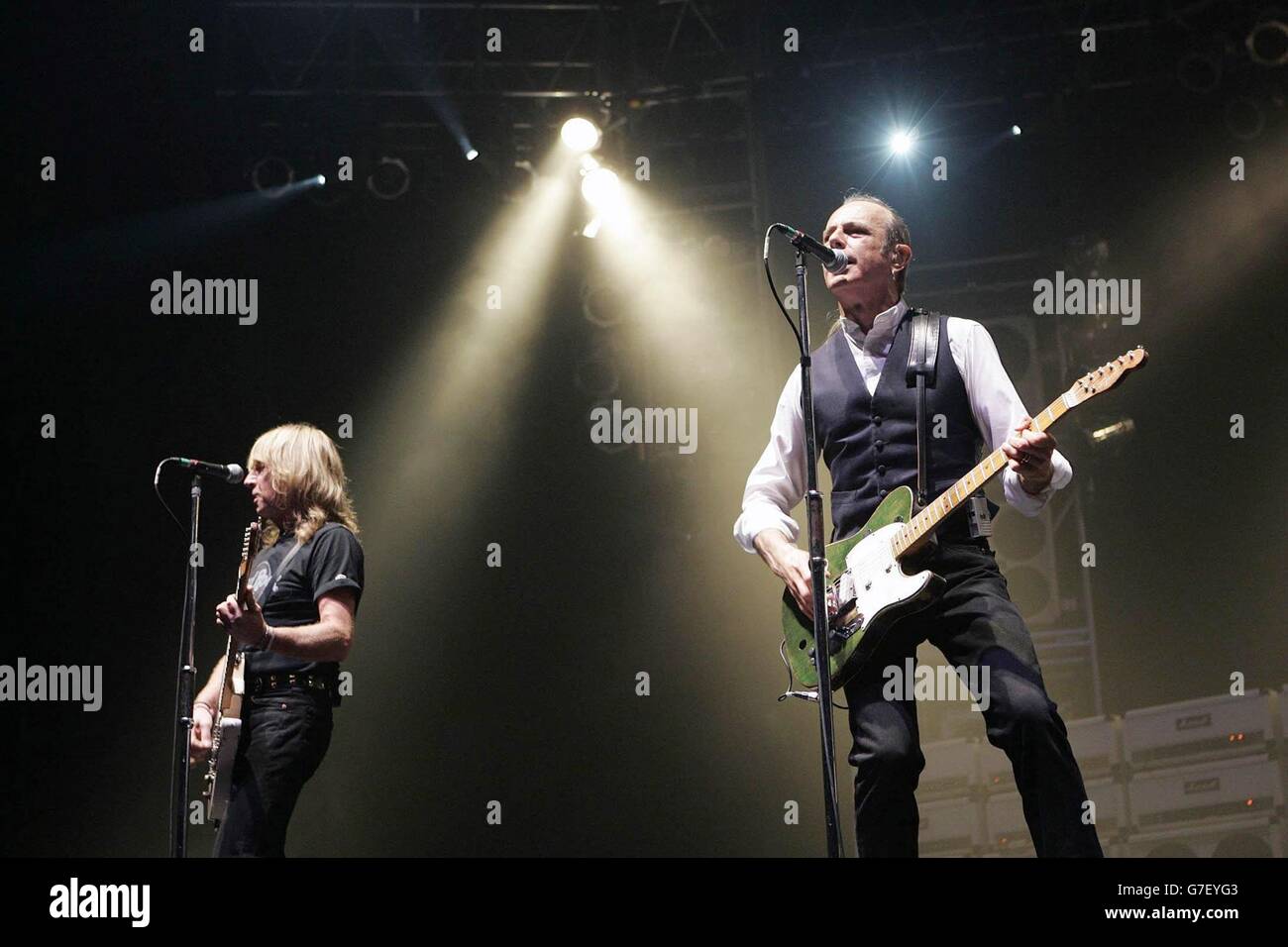 Die Gitarristen Rick Parfitt (L) und Francis Rossi von der Rockgruppe Status Quo auf der Bühne, während ihres Konzerts in der Wembley Arena in London. Stockfoto