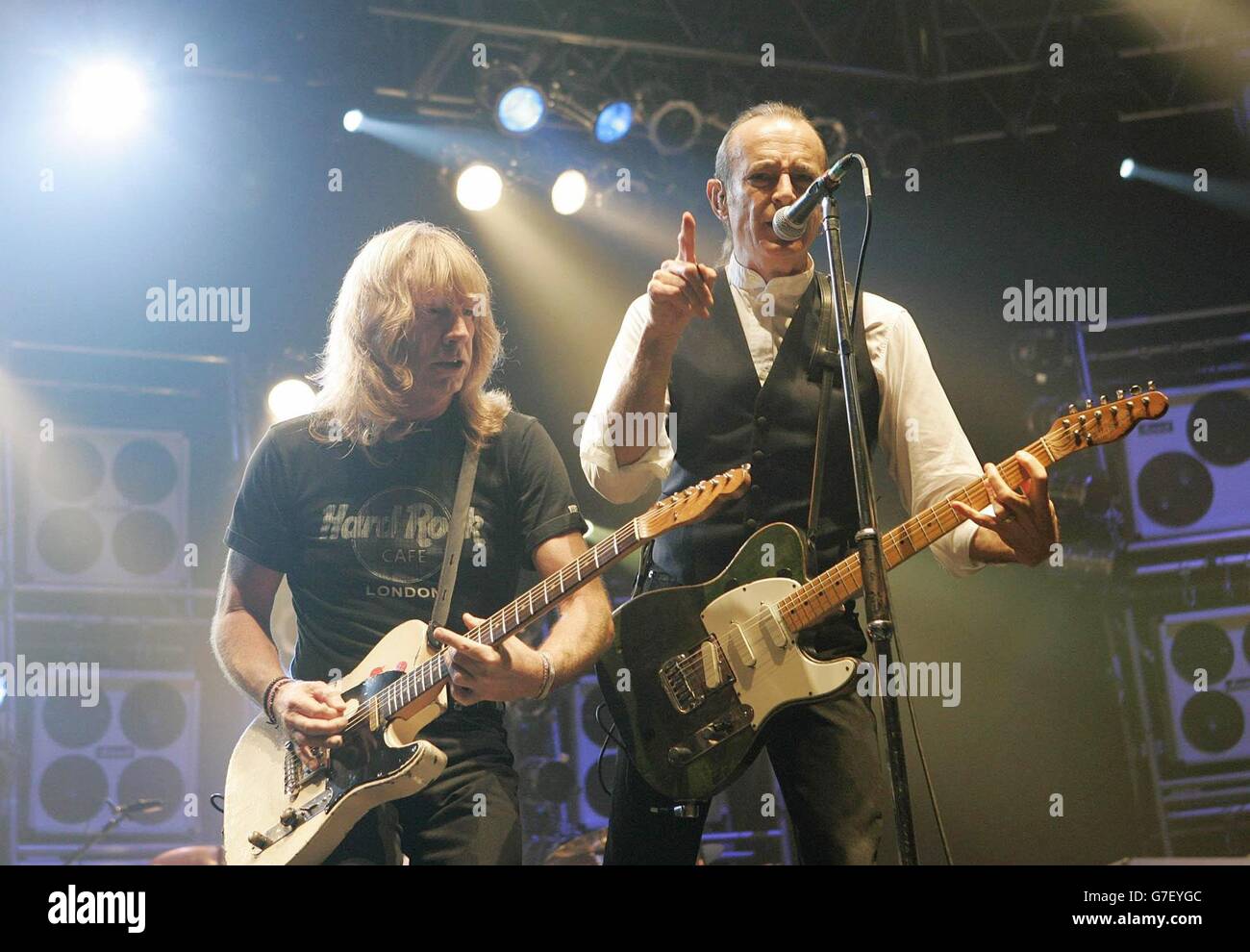 Die Gitarristen Rick Parfitt (L) und Francis Rossi von der Rockgruppe Status Quo auf der Bühne, während ihres Konzerts in der Wembley Arena in London. Stockfoto
