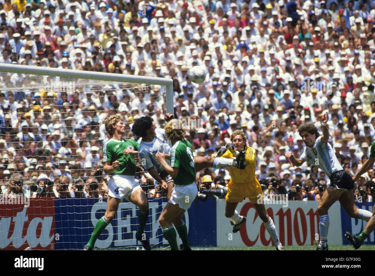 Argentiniens Diego Maradona (c) in der Westdeutschen Box als Torwart Harald Schumacher versucht, den Ball zu räumen. Ebenfalls für die Bundesrepublik abgebildet sind die Verteidiger Karlheinz Forster und Andreas Brehme. Stockfoto