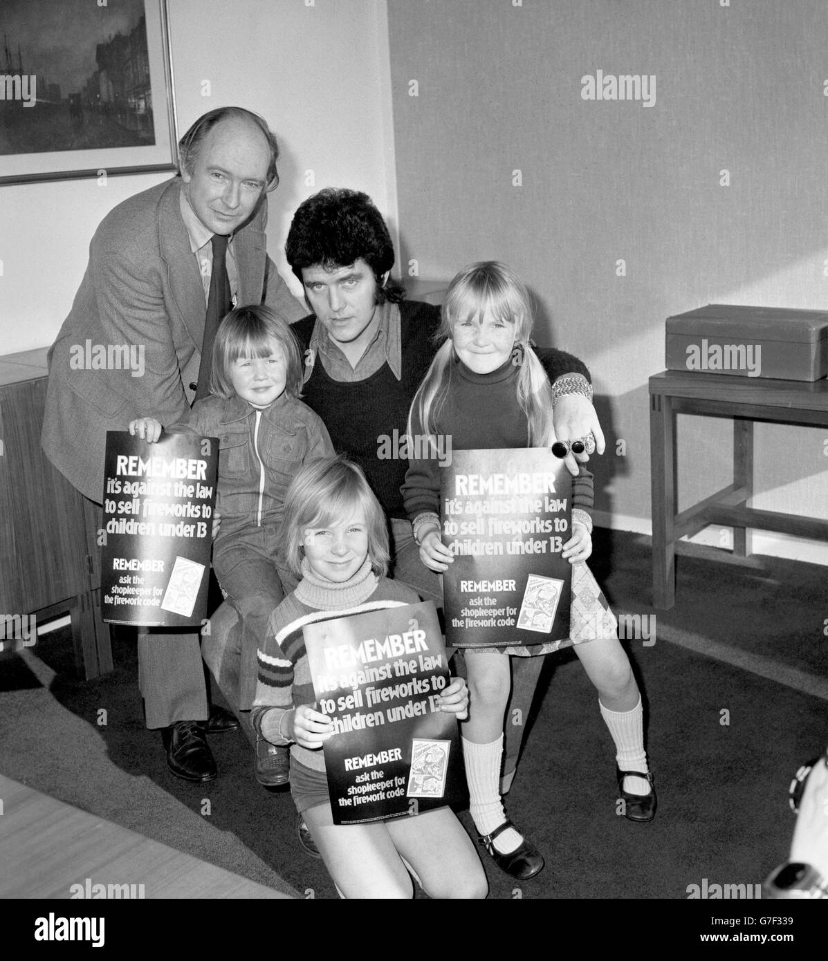 Pop-Sänger Alvin Stardust besucht im Rahmen ihrer Kampagne zur Sicherheit von Feuerwerkskampagnen das Department of Prices and Consumer Protection. Er ist mit Alan Williams, Staatsminister mit besonderer Zuständigkeit für die Sicherheit von Feuerwerken, und Williams' Kindern Robin, Sian (rechts) und Ian (vorne) zusammen. Stockfoto