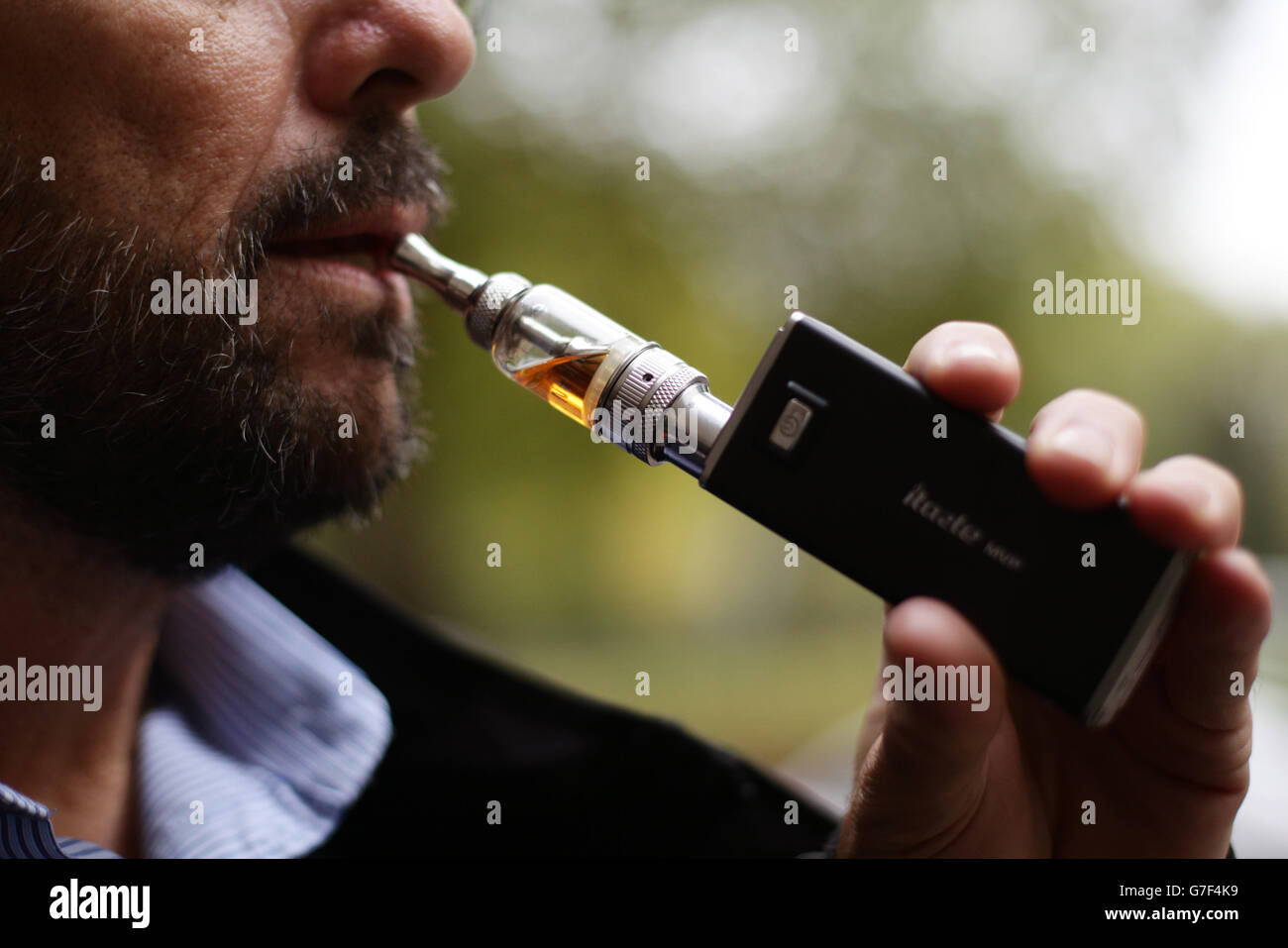 Ein Mann, der in London eine elektronische Zigarette (E-Zigarette, persönlicher Vaporizer (PV) oder elektronisches Nikotinausgabesystem (ENDS)) raucht. Stockfoto