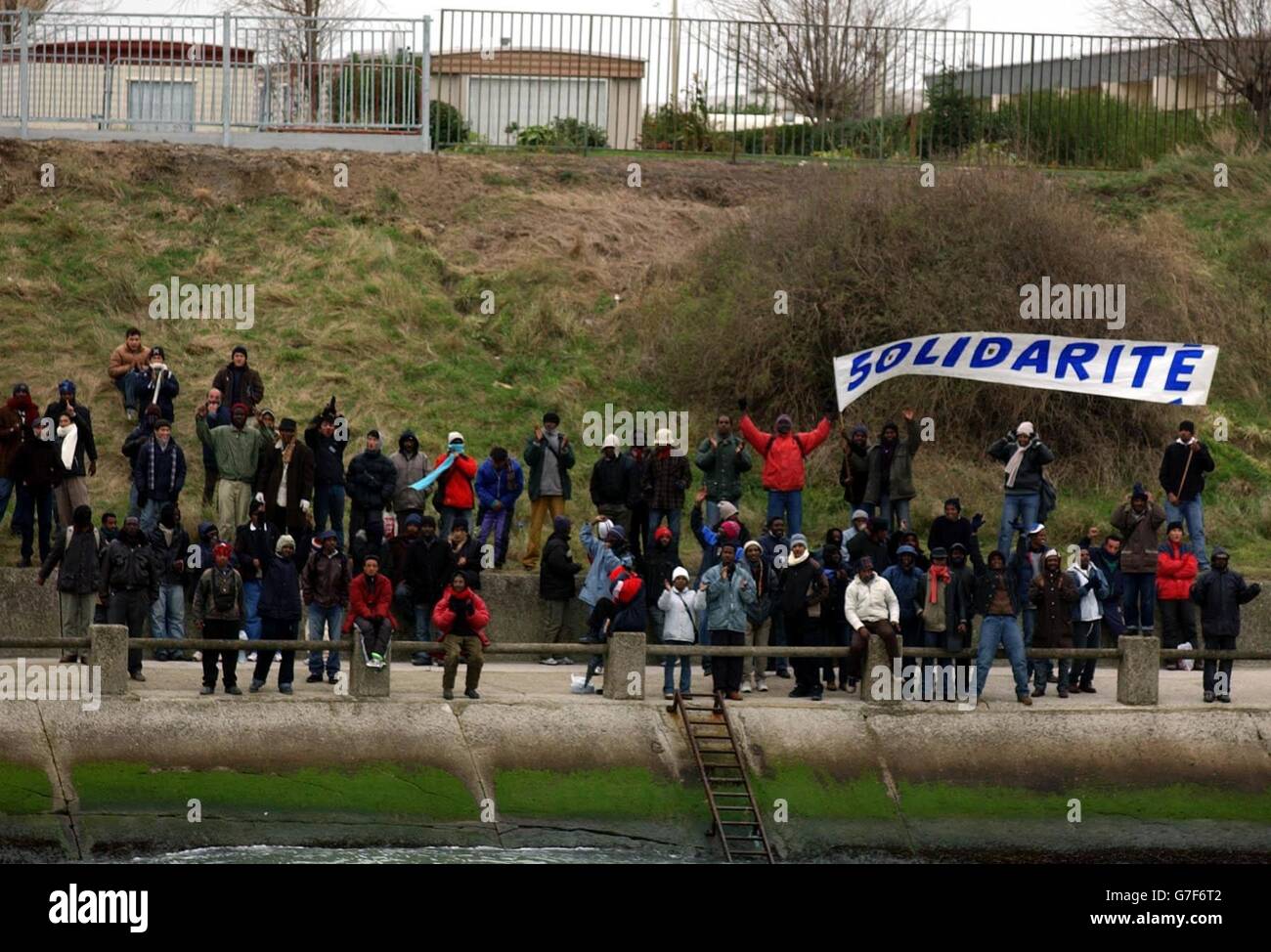 Eine Gruppe von Demonstranten protestiert in der Nähe der Docks von Calais in Calais, Frankreich, als der britische Innenminister David Blunkett mit dem französischen Innenminister Dominique de Villepin zusammentraf. Das Paar besichtigte früher die Docks, um neue Maßnahmen zu sehen, die dazu beitragen werden, zu verhindern, dass illegale Einwanderer von Frankreich nach Großbritannien geschmuggelt werden. Stockfoto