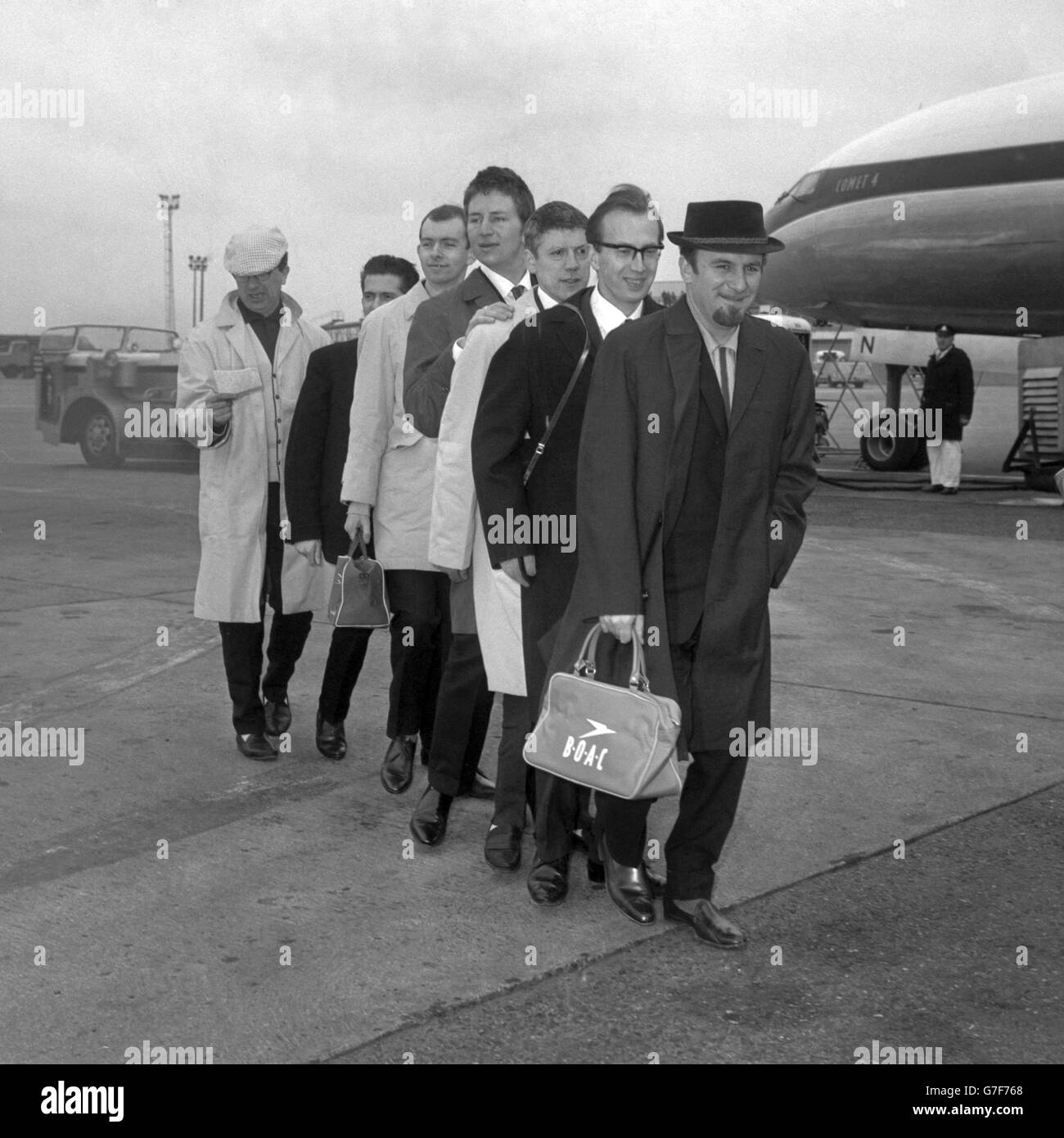 Mitglieder seiner Paramount Jazz Band folgen Acker Bilk (r) zu einem BOAC Liner am London Airport. Acker und seine Musiker flogen zu einer fünfwöchigen Tour durch Neuseeland, Australien, Singapur, Kuala Lumpur und Hongkong. Stockfoto
