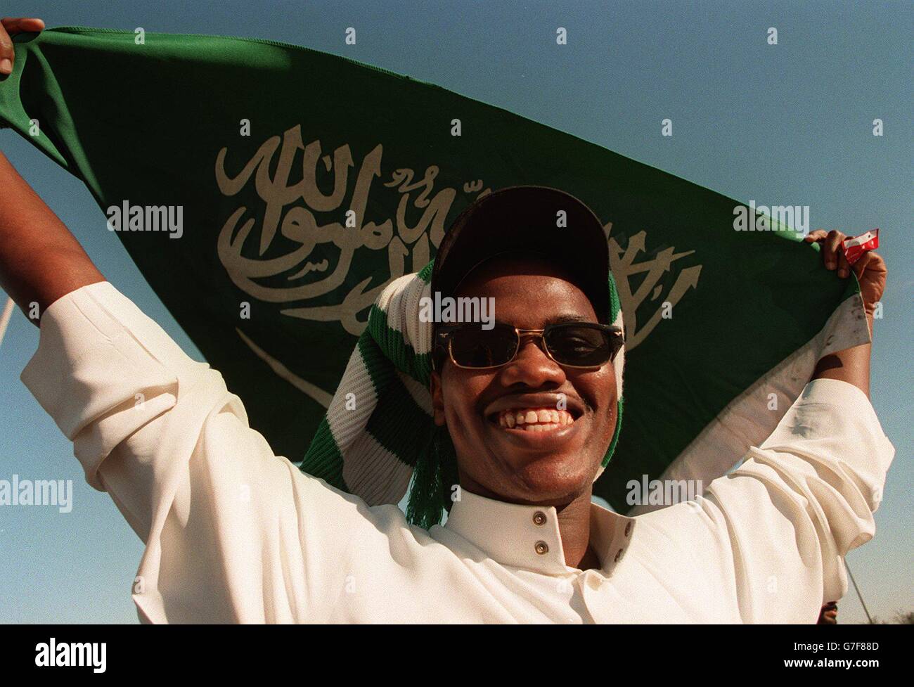 International Soccer - Asia 96 - Vereinigte Arabische Emirate (VAE) - Kuwait - Halbfinale. Ein Saudi-arabischer Fan, der beim Asia 96 Fußballturnier die Flagge seines Landes führt Stockfoto
