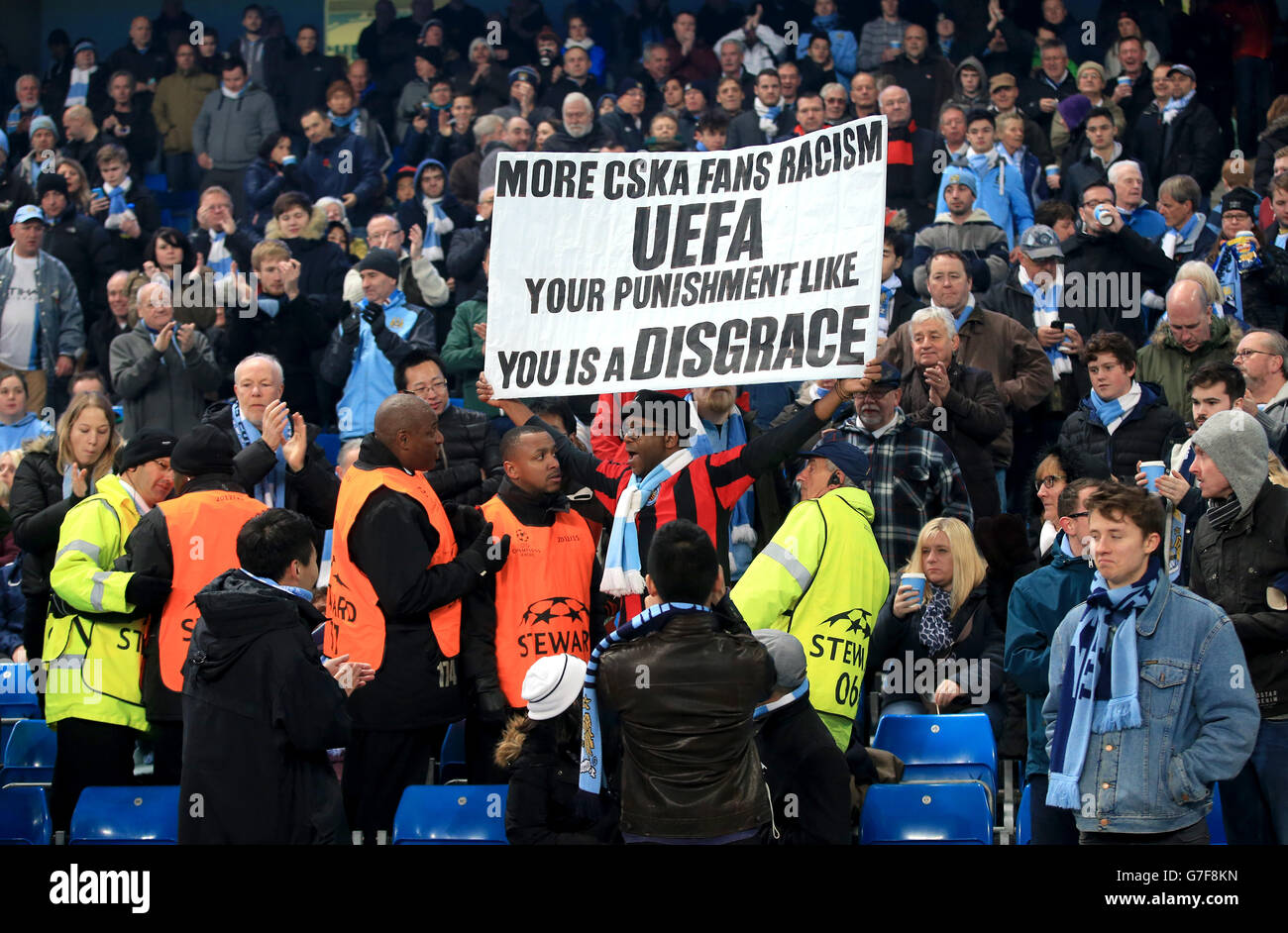Ein Fan von Manchester City hat sein Banner, das den Umgang der UEFA kritisiert Von CSKA Moskau Fans von Stewards entfernt Stockfoto