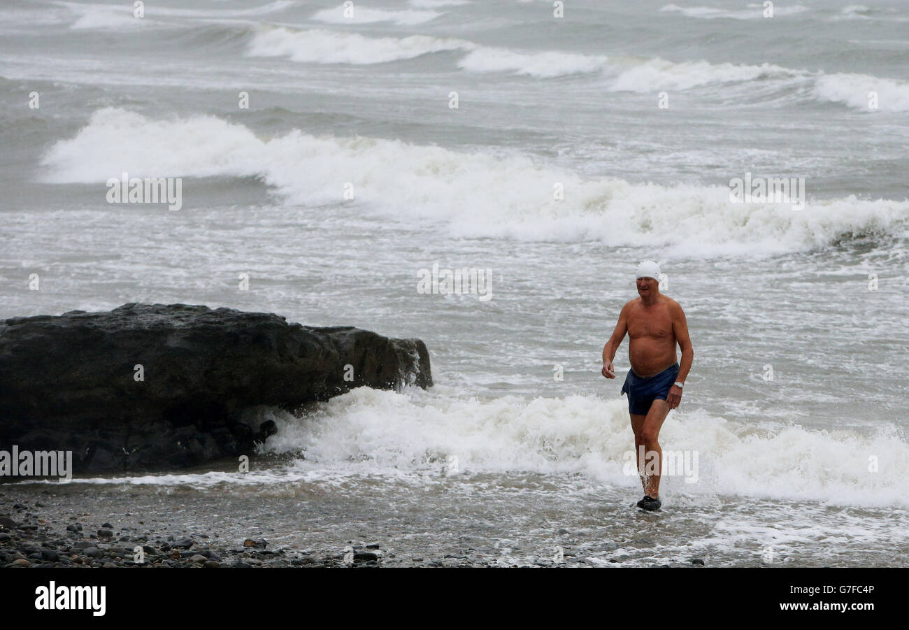 Ein Mann verlässt das Meer, nachdem er trotz der widrigen Wetterbedingungen in Portmarnock, Dublin, schwimmen gegangen ist. Stockfoto