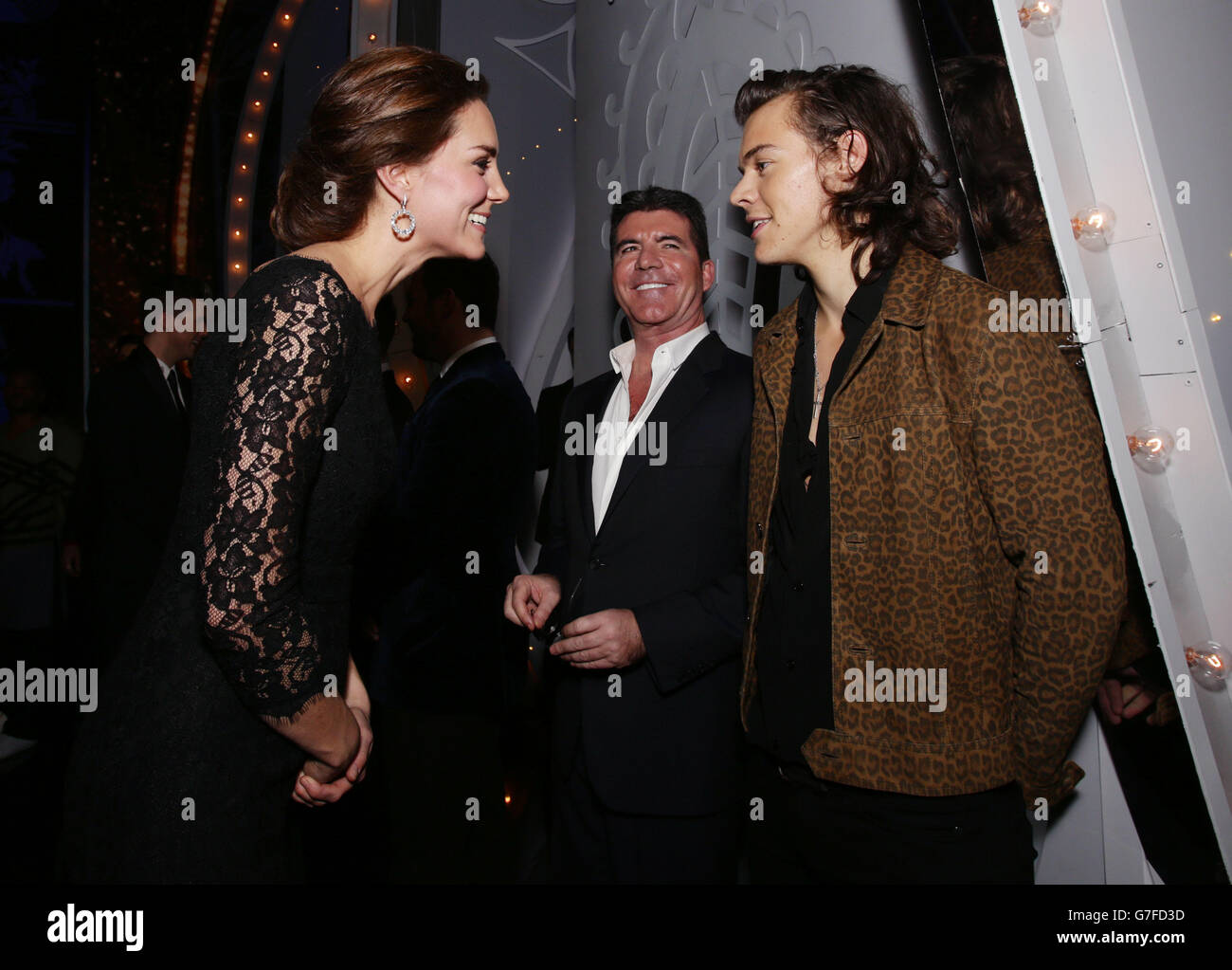 Die Herzogin von Cambridge trifft Harry Styles of One Direction, während Simon Cowell am Ende der Royal Variety Performance im Palladium Theatre in London nachschaut.die Veranstaltung ist zur Unterstützung des Wohlwollenden Fonds der Entertainment Artistes. Stockfoto