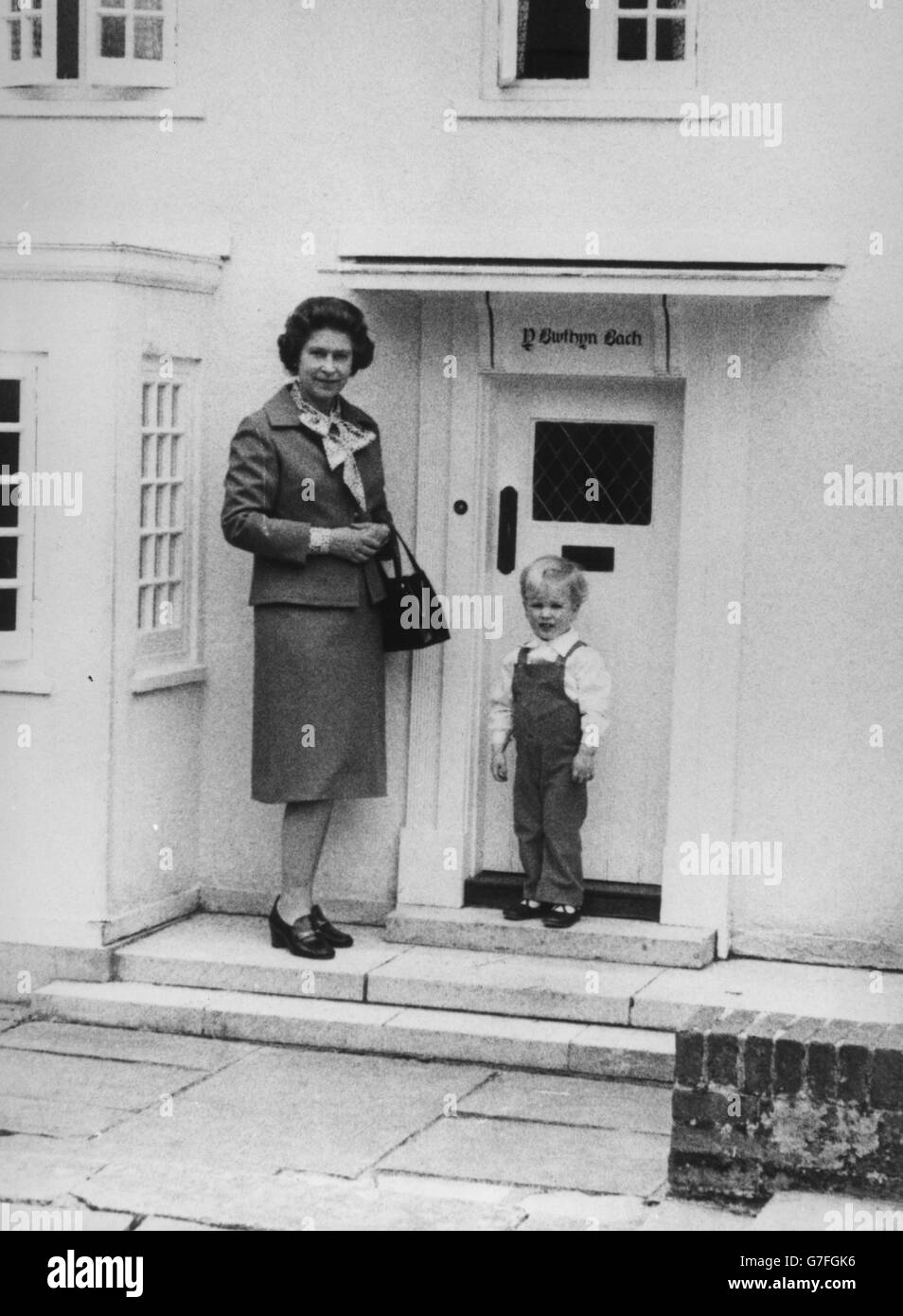 Königin Elisabeth II. Mit ihrem Enkel Meister Peter Phillips, als er Y Bwthyn Bach zum ersten Mal besuchte. Die Miniatur Welsh Cottage liegt auf dem Gelände der Royal Lodge im Windsor Great Park und ist auf die Größe eines Kindes skaliert. Es wurde der Königin von Wales im Jahr 1931 gegeben, als sie Prinzessin Elizabeth von York war. Stockfoto
