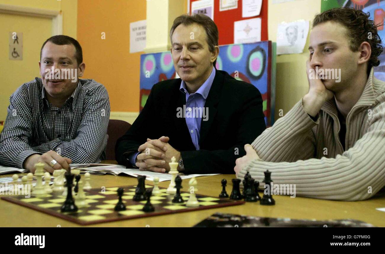 Premierminister Tony Blair (C) beobachtet junge Menschen beim Schachspielen während eines Besuchs im New Horizon Youth Centre in London. Das Zentrum, das mit obdachlosen und arbeitslosen jungen Menschen im Alter von 16 bis 21 Jahren arbeitet, hat von der Finanzierung des BBC-Programms Children in Need profitiert. Stockfoto
