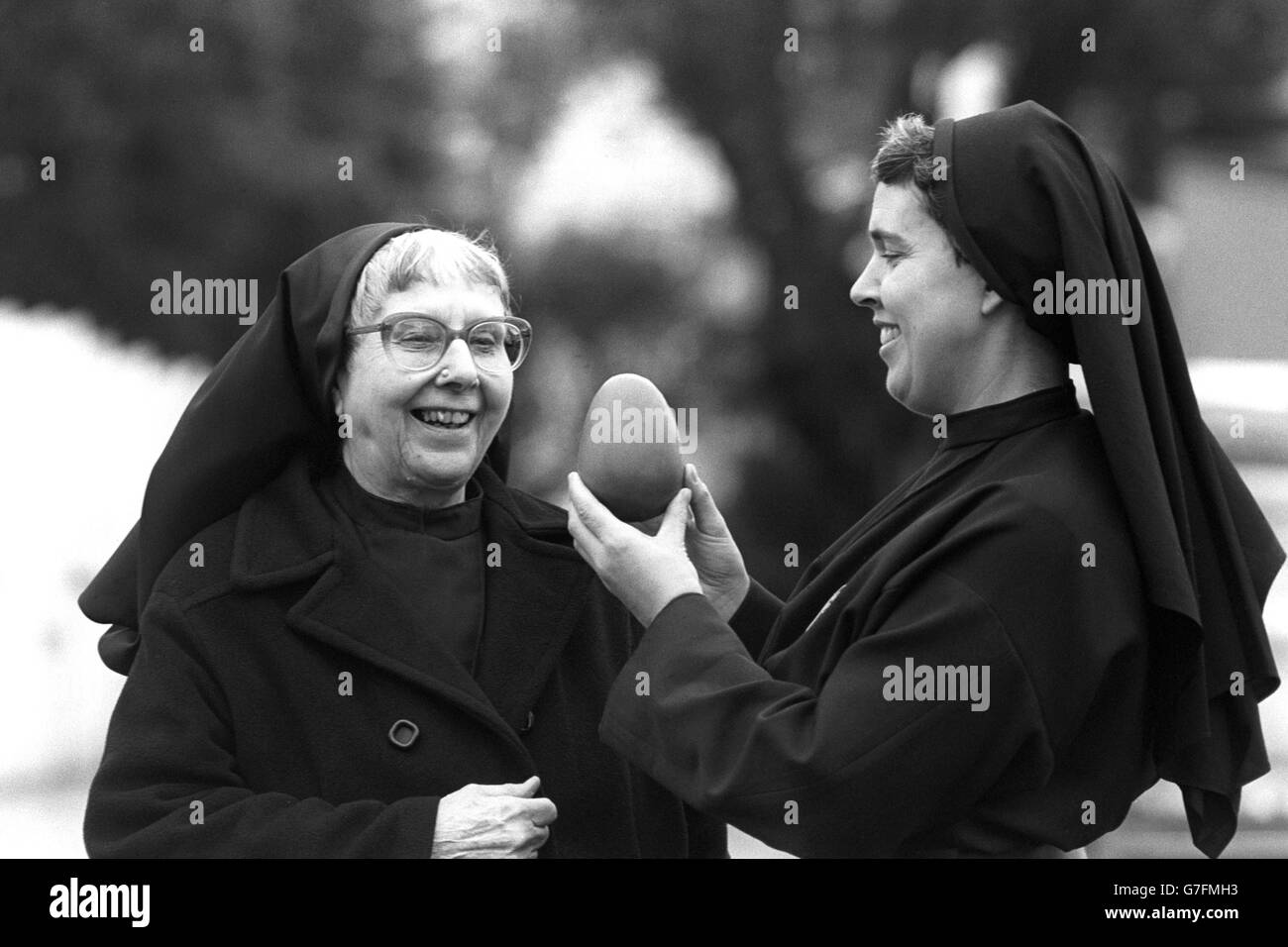 Ein süßer Moment für die Nonnen des Klosters unserer Lieben Frau von Leidenschaft, Mutter Catherine (l.) und Schwester Miriam, als sie auf ihrem Erkundungsausflug zu einer Schokoladeneierfabrik aus Jersey, dem Hotel de France, ein Schokoladenei in Erwägung zogen. Die Nonnen, die vor kurzem einen Kampf vor dem Obersten Gerichtshof verloren haben, um die Tötung von 5,000 ihrer angeblich mit Salmonellen infizierten Hühner zu stoppen, hoffen, bis Ostern in Daventry ein Schokoladenunternehmen zu starten. Stockfoto