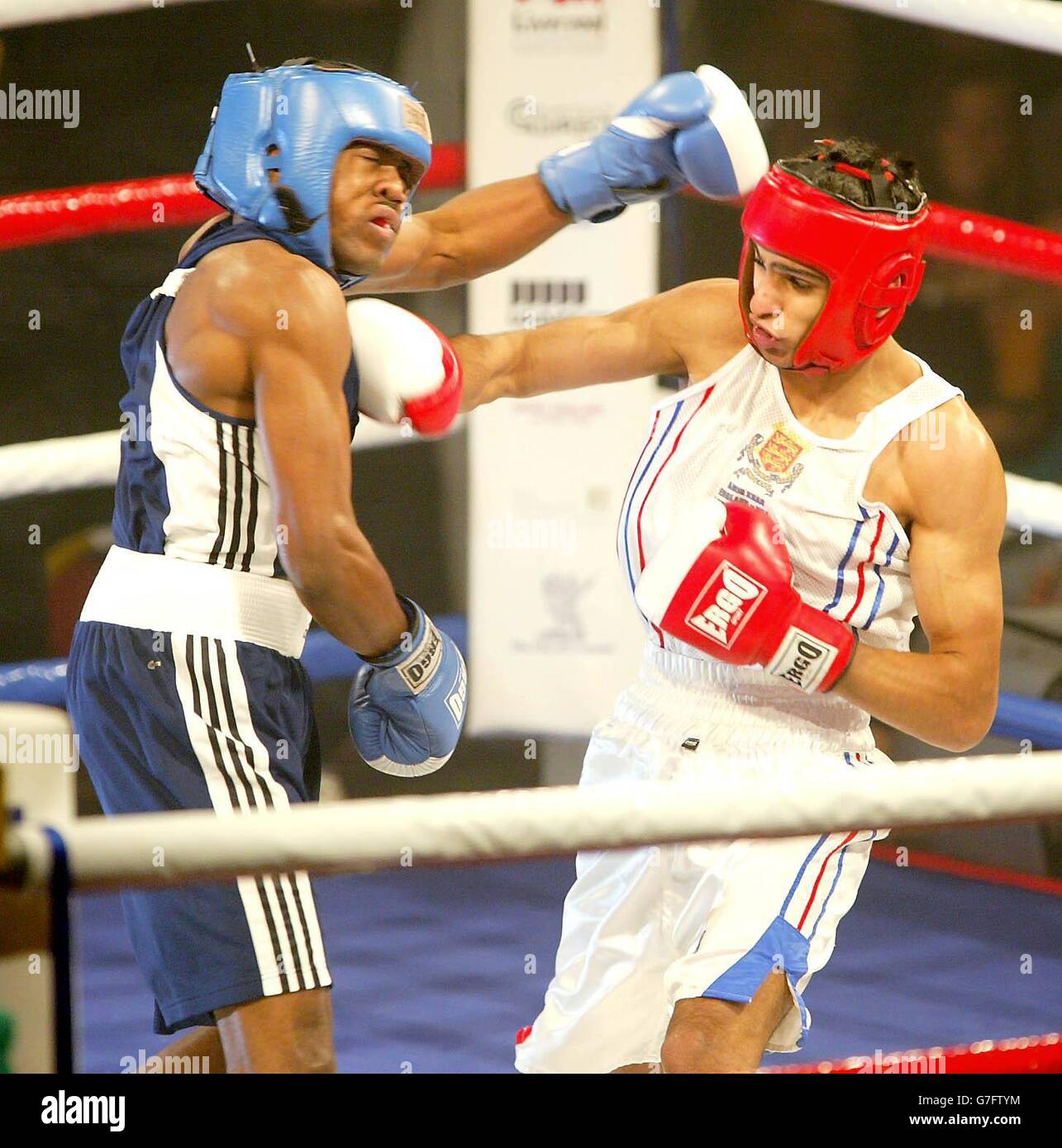 Der englische Amir Khan im Kampf gegen den US-amerikanischen Michael Evans während ihres 60 kg schweren Kampfs im Liverpool Olympia, Liverpool. Khan kehrte drei Monate nach seinem olympischen Silbermedaillenruhm in Athen triumreich zum Ring zurück, als er Evans 35-13 im Amateurinternational besiegte. Khan hob seine Arme zur Anerkennung am Ende, als die Kapazitätsmenge sich erhob, um seinen großartigen, einseitigen Sieg zu bestätigen. Stockfoto