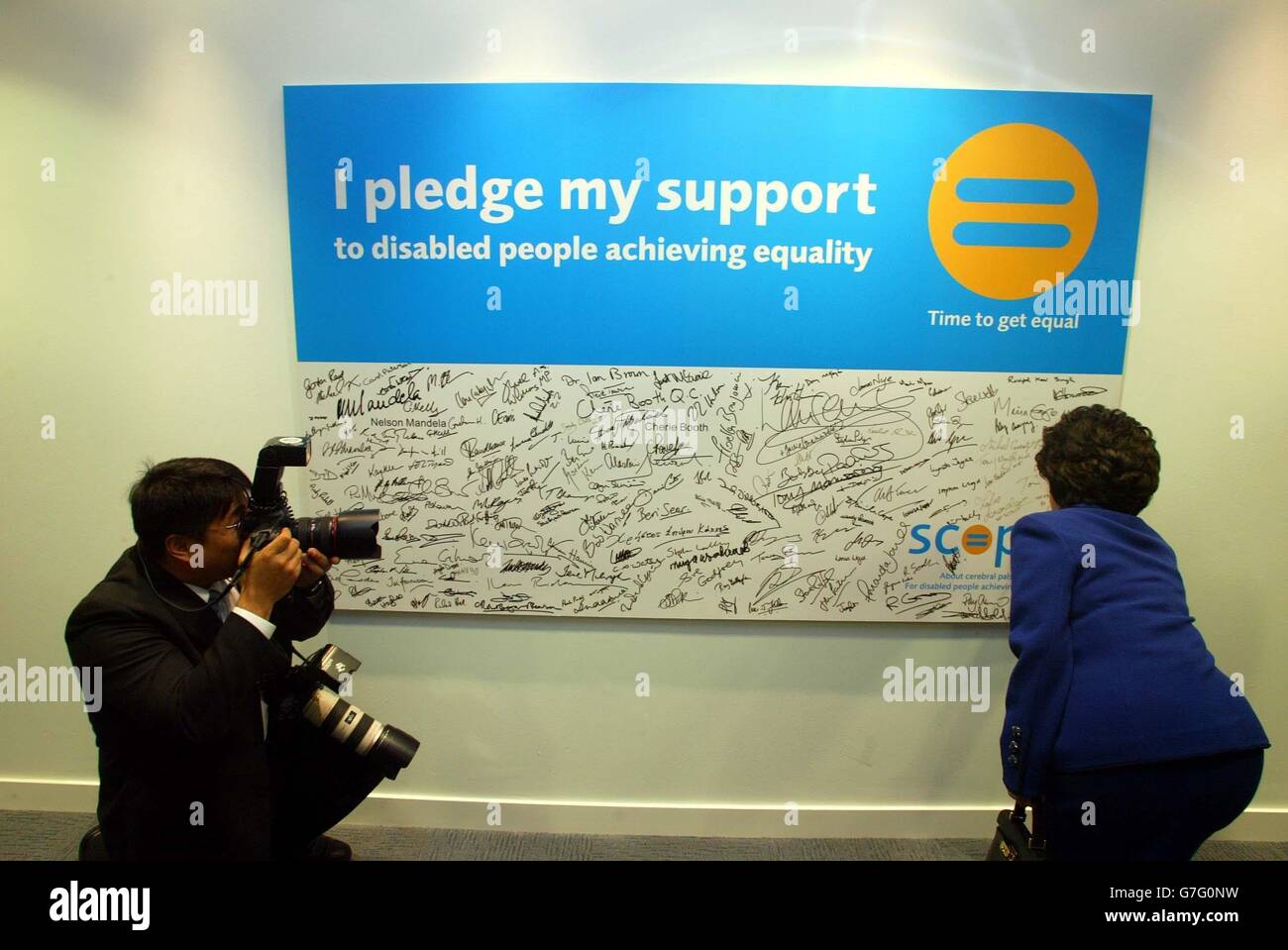 Die Frau des Präsidenten von Südkorea, Madame Roh, unterschreibt ihren Namen auf dem Scope 'Time to get equal' Kampagnenplakat, unter den Unterschriften von Prominenten, während eines Besuchs im Scope HQ, London, mit der Frau des britischen Premierministers, Cherie Blair Stockfoto