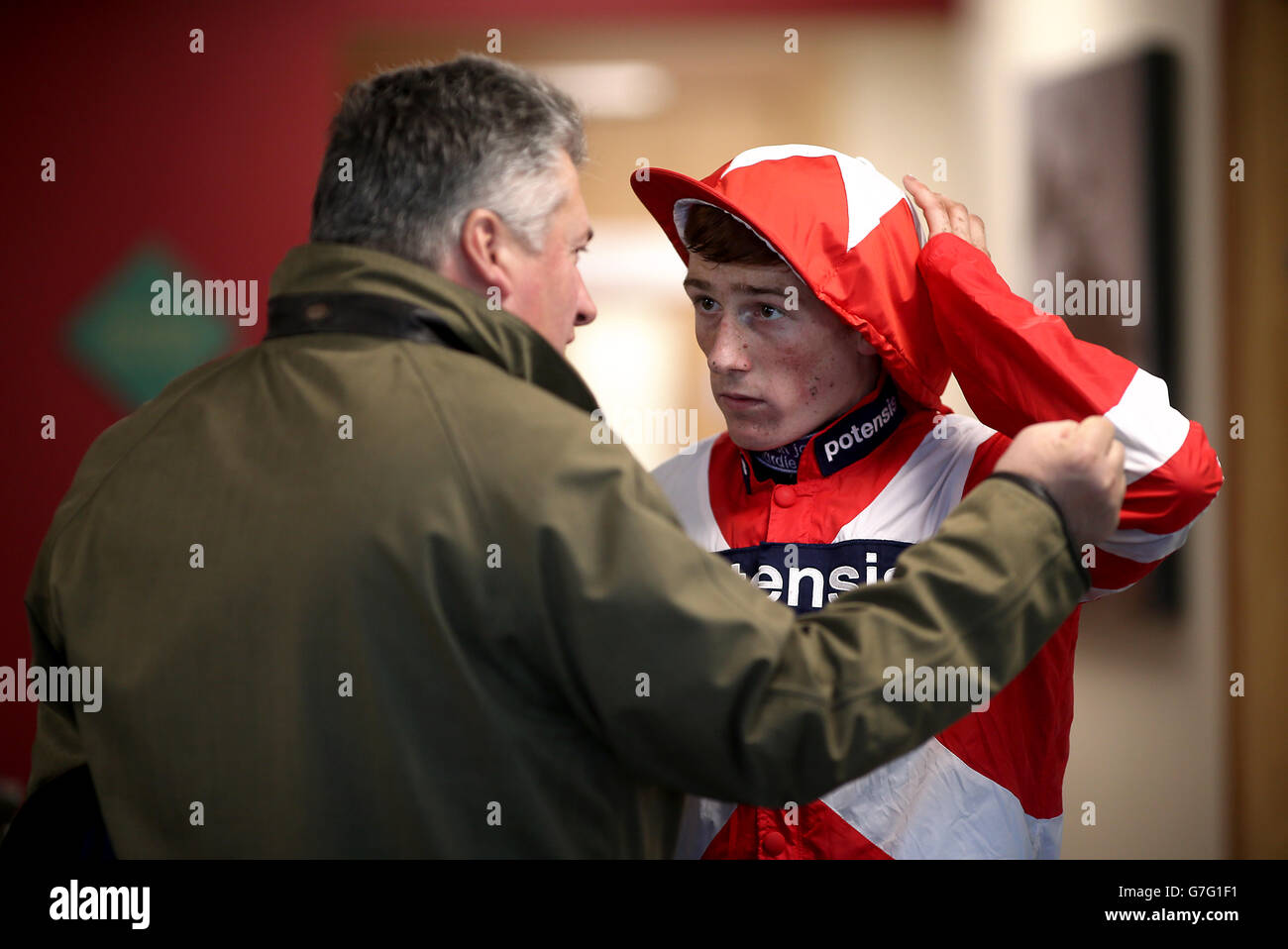 Jockey Sam Twiston-Davies chattet mit Trainer Paul Nicholls während des ersten Tages der Open auf der Cheltenham Racecourse. Stockfoto