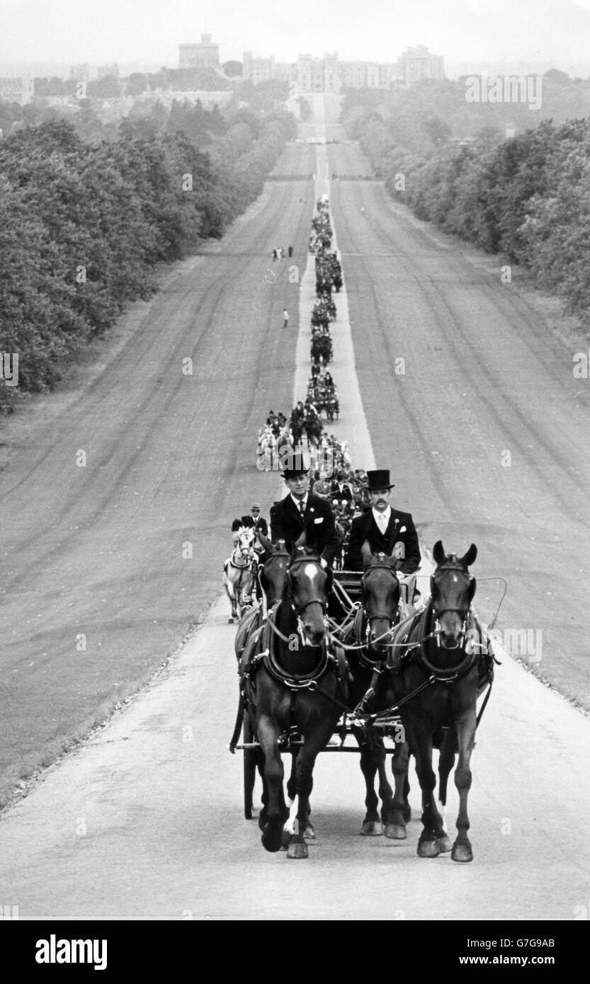Windsor Castle steht im Hintergrund, als der Herzog von Edinburgh und David Saunders (r) während der Eröffnungsfeier der Wettbewerbe die Prozession von 40 Teilnehmern für die World Driving Championships auf dem Long Walk führen. Der Duke ist Präsident des Wettbewerbs und auch ein Teilnehmer des Rennens. *Eingescannte Low-Res aus dem Druck, High-Res auf Anfrage* Stockfoto