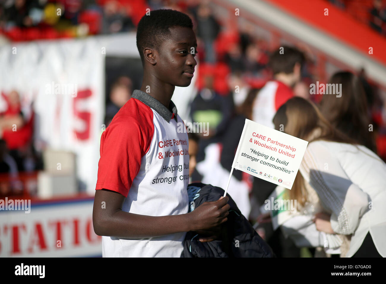 Fußball - Sky Bet Championship - Charlton Athletic gegen Ipswich Town - The Valley. Ein Charlton-Fan, der ein T-Shirt trägt und eine Flagge hält, fördert CARE Partnership & Woolwich United. Stockfoto