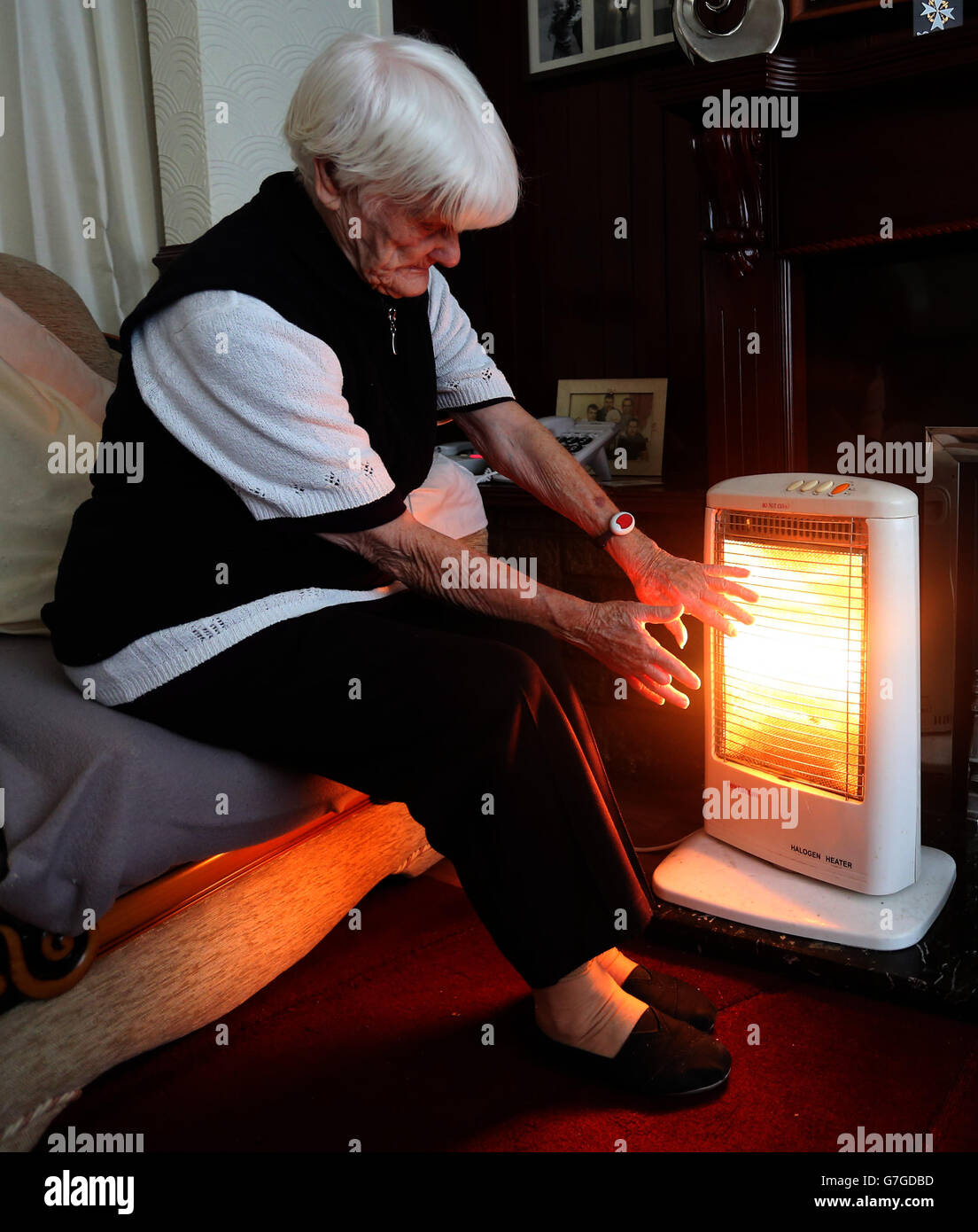 Ein generisches Stockfoto einer älteren Dame mit ihrem Elektrofeuer zu Hause in Liverpool. Stockfoto