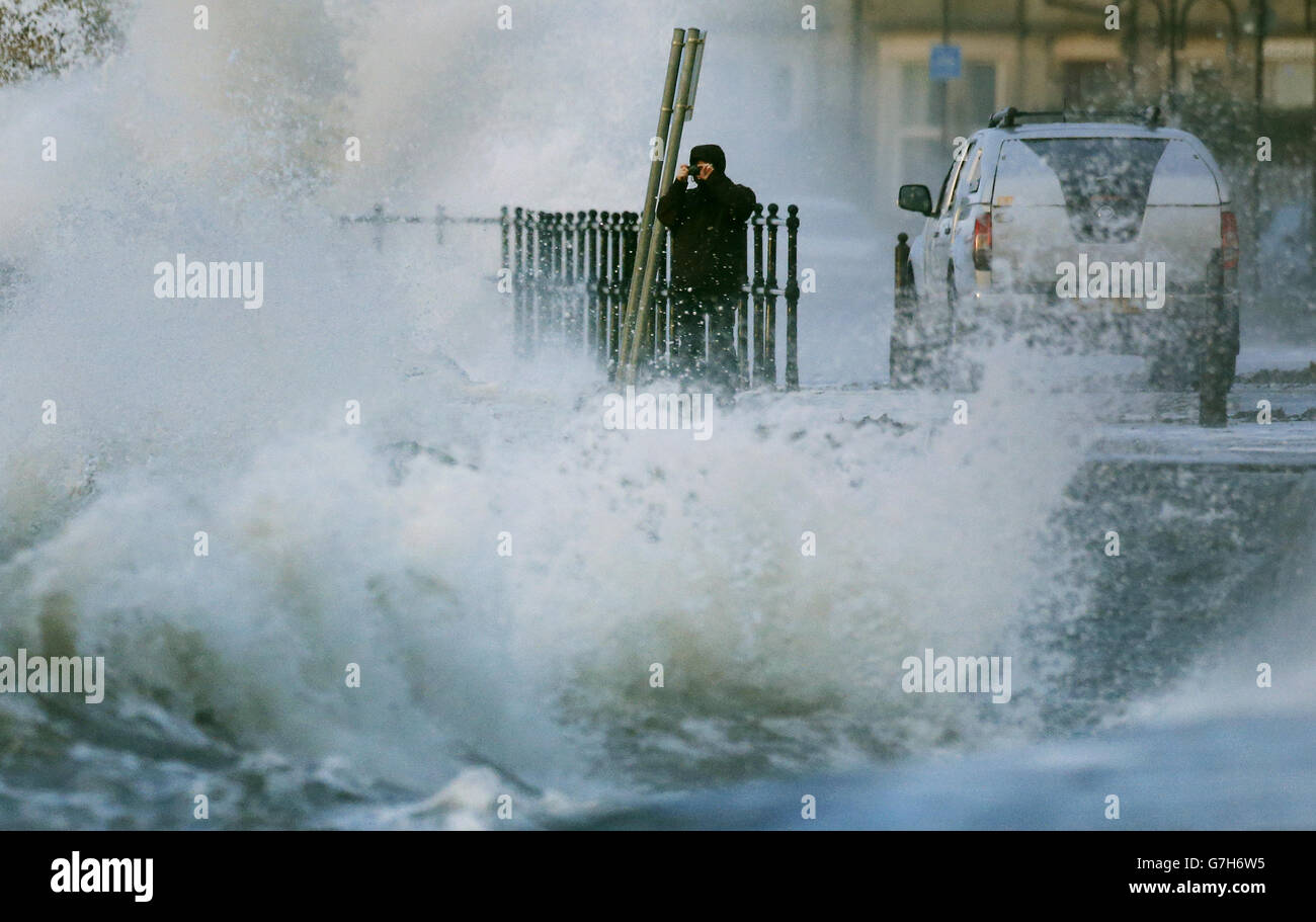 Ein Mann fotografiert am Meer in Largs , Schottland, da Großbritannien von einer "Wetterbombe" geschlagen wird. Stockfoto