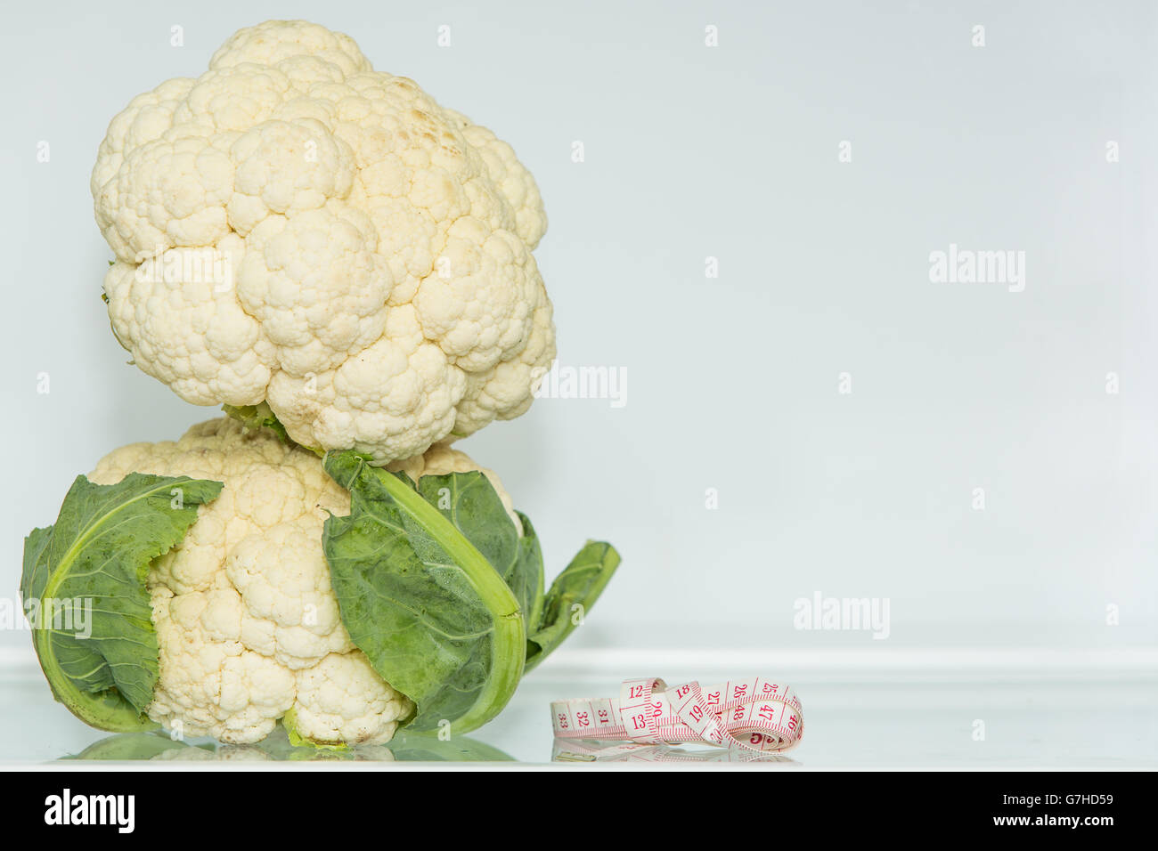 Das zwei Blumenkohl mit Maßband (2). Gesunde Ernährung. Gesunde Lebensweise. Ernährung. Quelle für Vitamine. Vegetarier. Gewicht-Verlust. Stockfoto