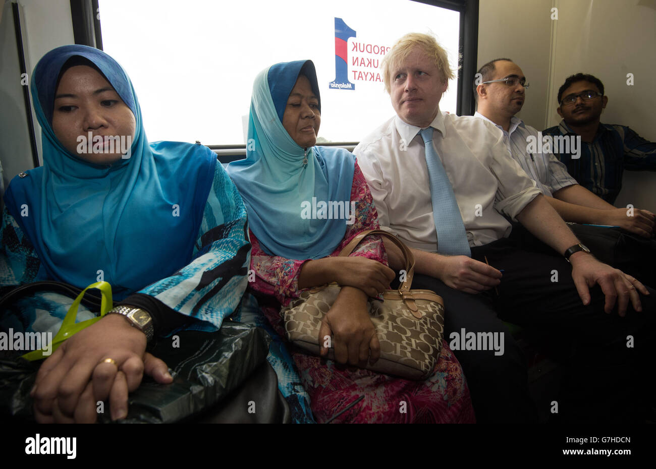 Der Bürgermeister von London, Boris Johnson, trifft im LRT-Zug lokale Pendler auf seiner Reise durch Kuala Lumpur, Malaysia, mit dem Bürgermeister der Stadt, Ahmad Phesal Talib, nachdem sie sich im Rathaus der malaysischen Hauptstadt traf. Stockfoto