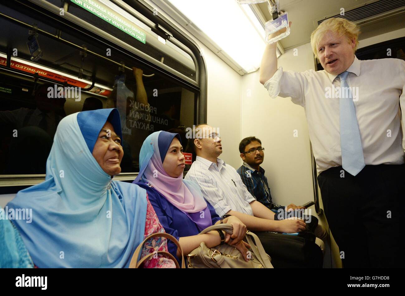 Der Bürgermeister von London, Boris Johnson, trifft im LRT-Zug lokale Pendler auf seiner Reise durch Kuala Lumpur, Malaysia, mit dem Bürgermeister der Stadt, Ahmad Phesal Talib, nachdem sie sich im Rathaus der malaysischen Hauptstadt traf. Stockfoto