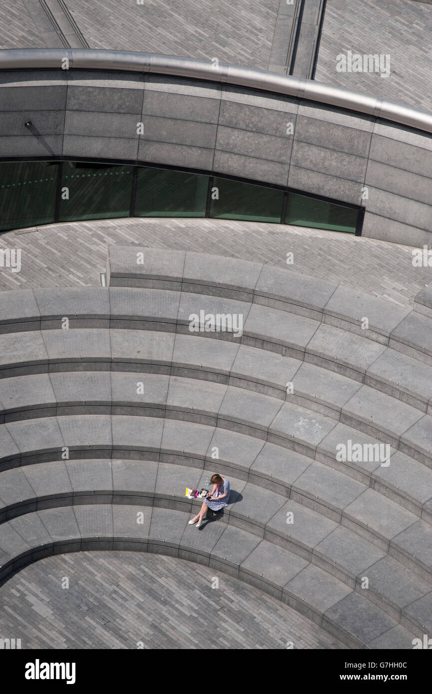 2016 London Bürgermeisterwahlen, Mitglied des Personals hat Mittagspause in The Scoop Amphitheater unter City Hall in London. Stockfoto