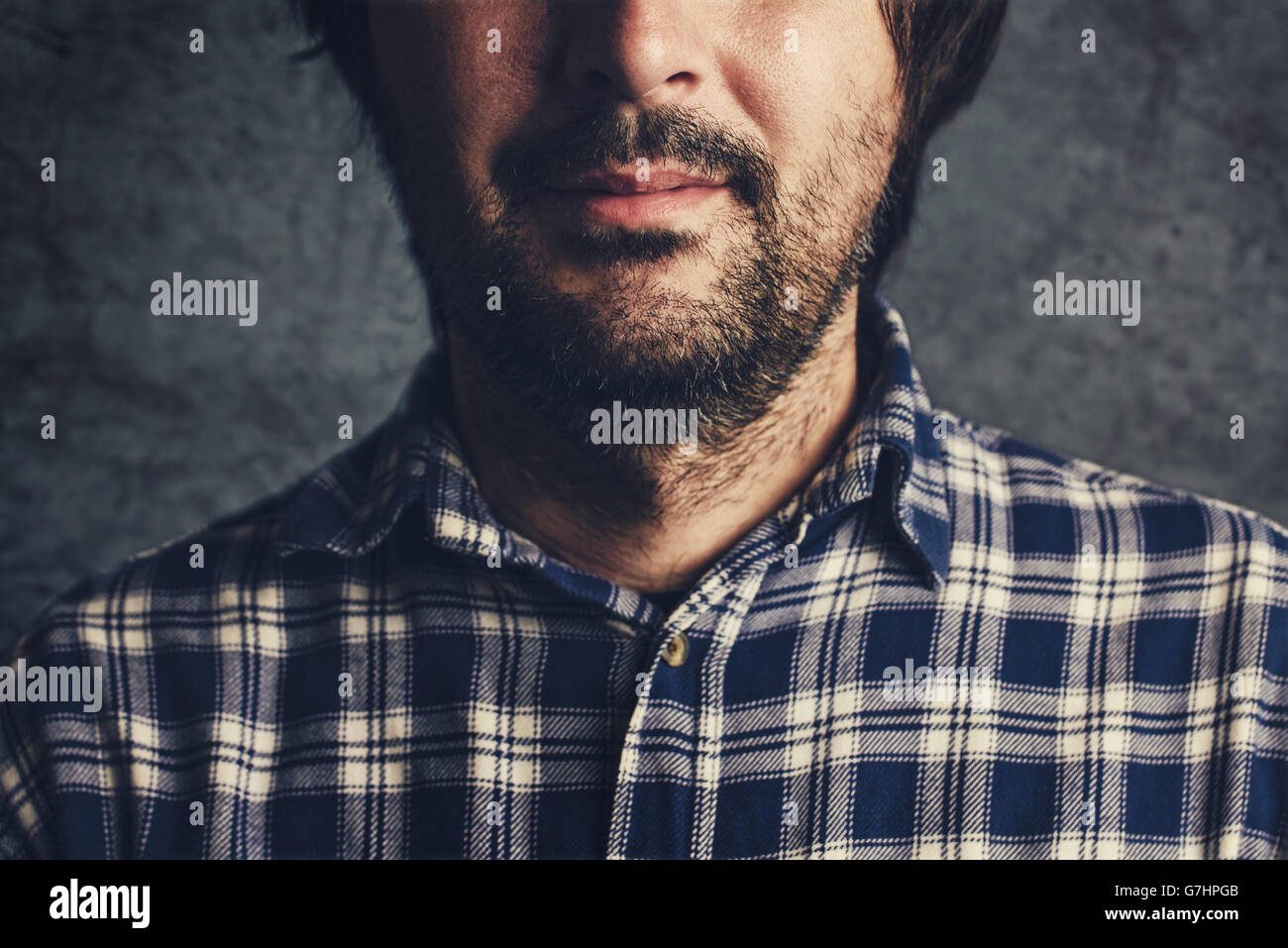 Legerer Mann im karierten Hemd lächelnd, denken und nachdenken, low Key, selektiven Fokus Porträt Stockfoto